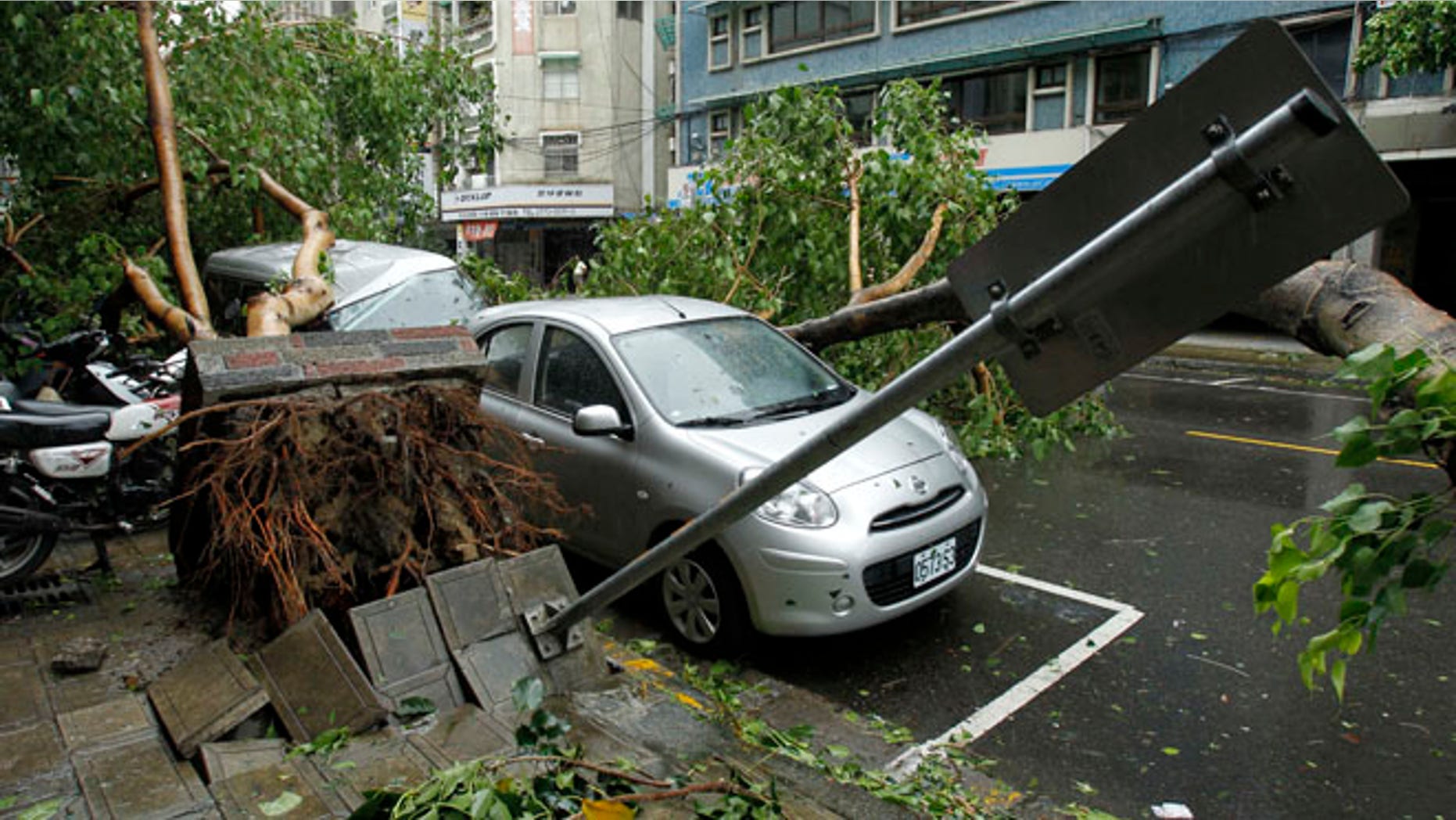 July 13, 2013: Fallen trees damaging vehicles lie on a street after Typhoon Soulik hit Taiwan in Taipei.