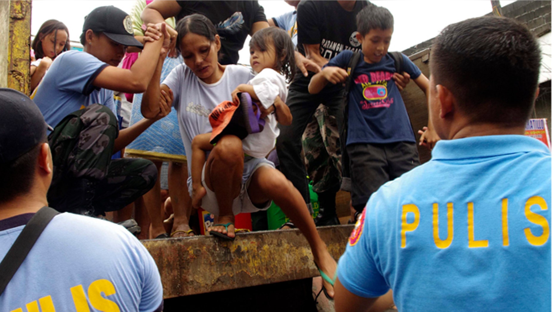 FILE: Nov. 7, 2013 Residents living near the slopes of Mayon volcano are evacuated to public schools by police before Typhoon Haiyan struck.