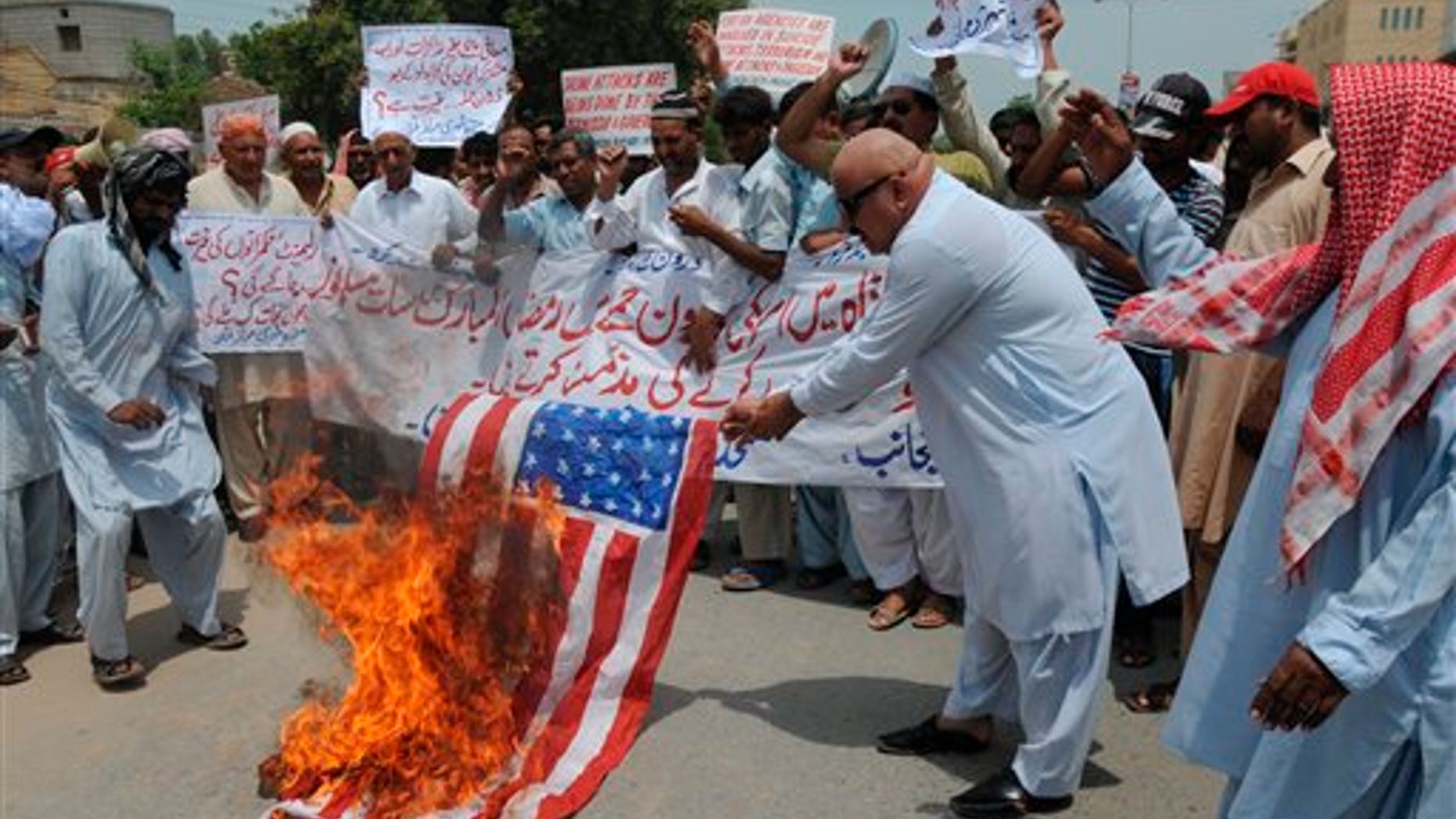 August 10: Pakistani protesters burn a representation of a US. flag to condemn drone attacks on militants' hideouts in Pakistani tribal area along the Afghanistan border, in Multan, Pakistan.