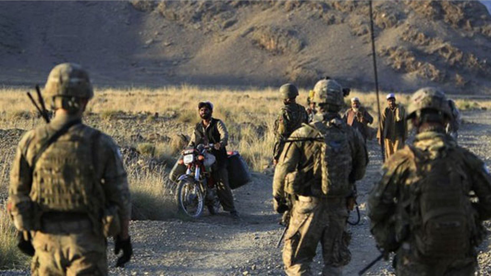 October 2: U.S. soldiers from Alpha Co, 2nd Battalion 35th Infantry, Task Force "Cacti" and Afghan soldiers check villagers along a road during a joint military patrol in Walay valley, near the Afghanistan-Pakistanborder in Kunar province.