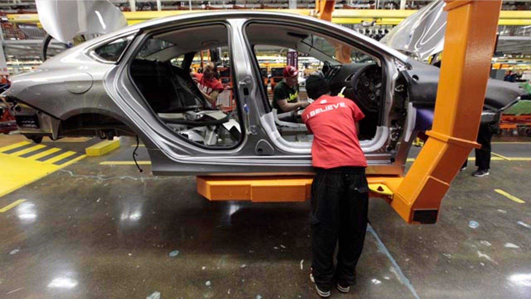 FILE - In this March 14, 2014 file photo, assembly line workers build a 2015 Chrysler 200 automobile at the Sterling Heights Assembly Plant in Sterling Heights, Mich. (AP Photo/Paul Sancya, File)