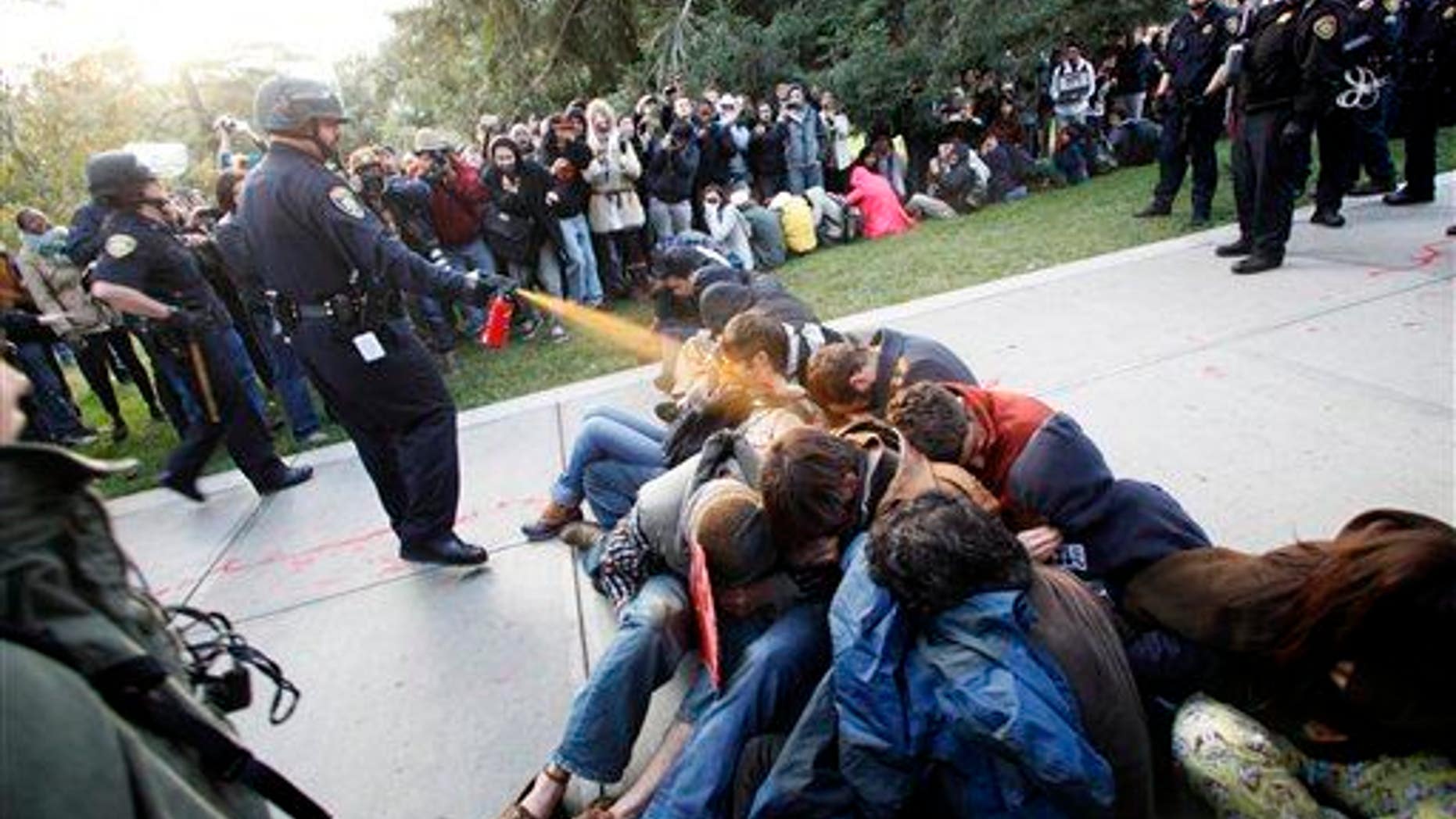 In this Nov. 18, 2011, file photo, University of California-Davis Police Lt. John Pike uses pepper spray on Occupy UC Davis protesters.