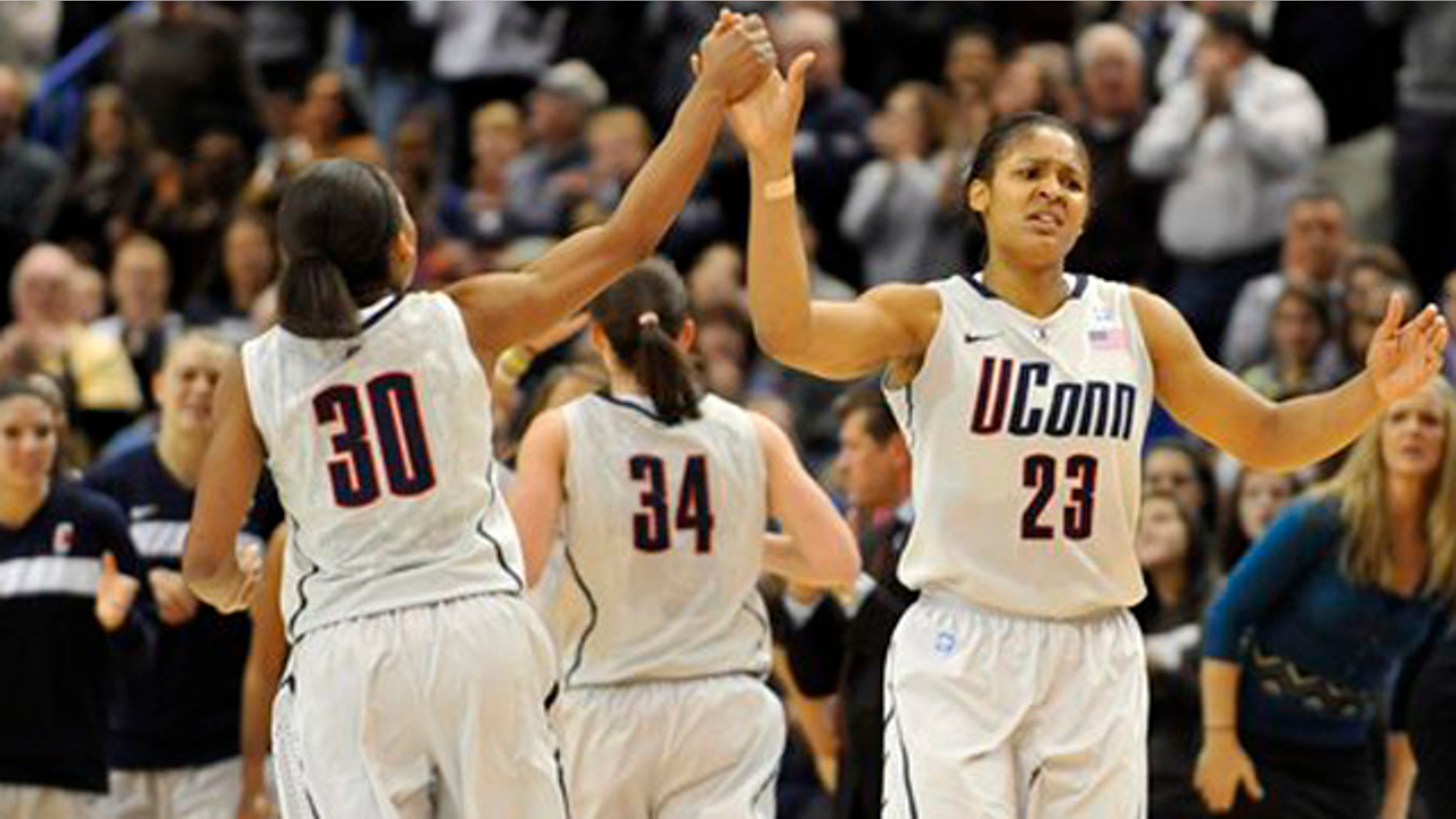 Dec. 5, 2010: Connecticut's Maya Moore, right, high-fives teammate Lorin Dixon after breaking UConn's all time scoring record.