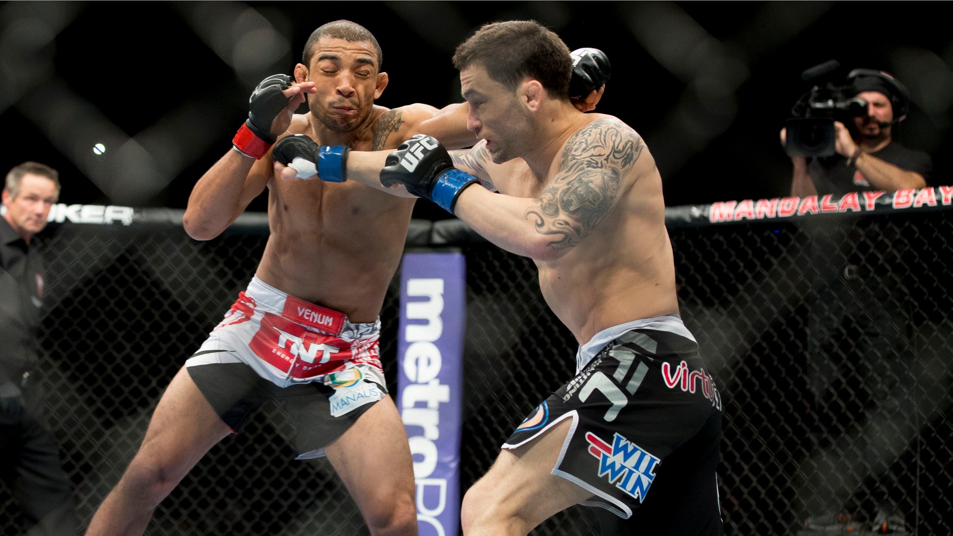 Jose Aldo, of Rio de Janeiro, left, trades punches with Frankie Edgar during their UFC 156 featherweight mixed martial arts title match, Saturday, Feb. 2, 2013 at The Mandalay Bay Resort & Casino in Las Vegas. Aldo won by unanimous decision. (AP Photo/Eric Jamison)