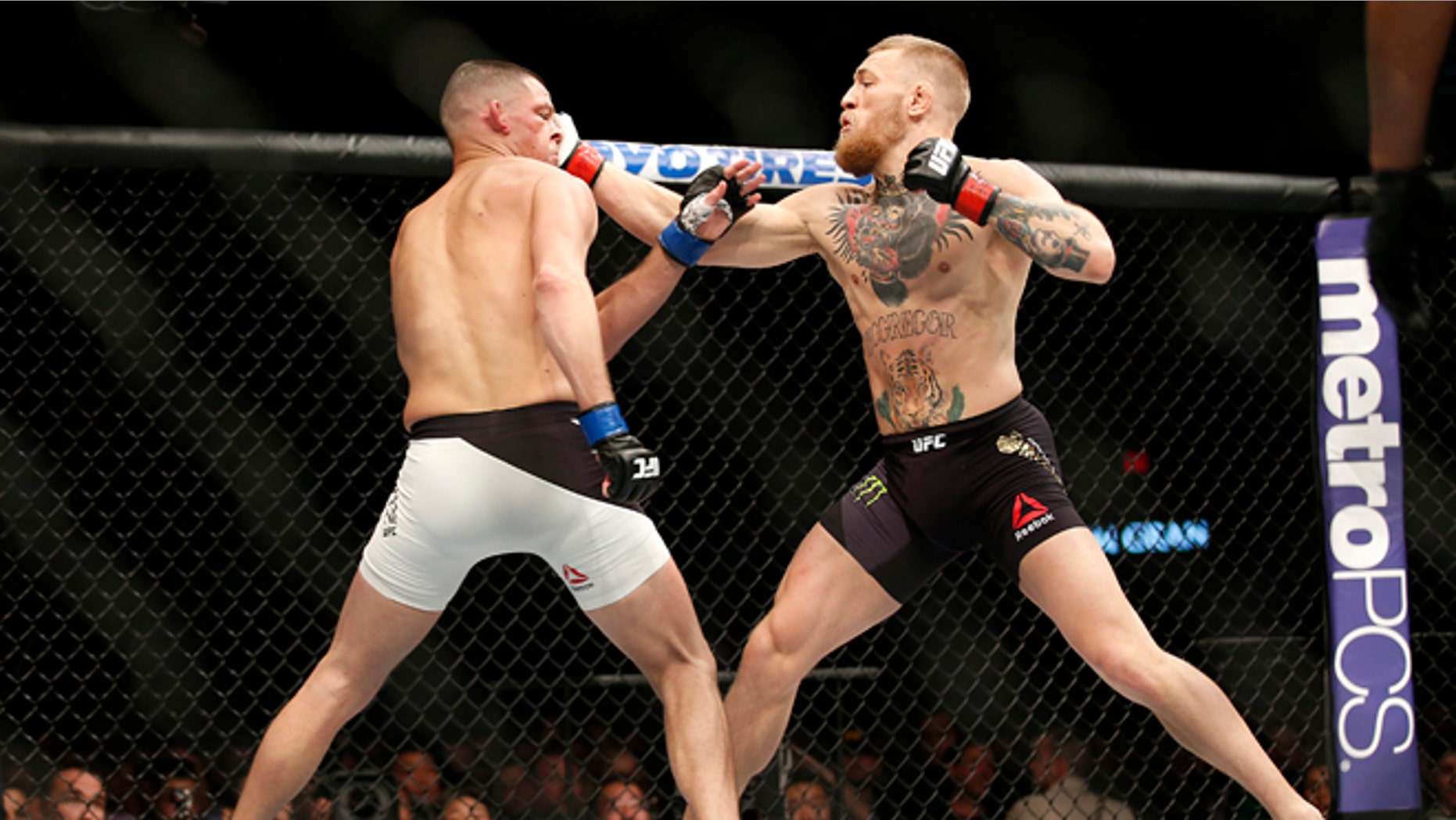 Nate Diaz, left, trades punches with Conor McGregor Saturday, March 5, 2016, in Las Vegas.