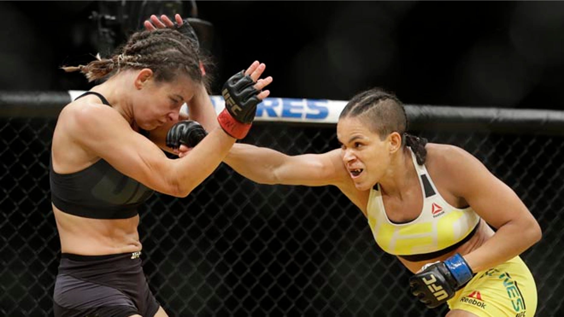 Amanda Nunes, right, hits Miesha Tate during their women's bantamweight championship mixed martial arts bout at UFC 200, Saturday, July 9, 2016, in Las Vegas. (AP Photo/John Locher)