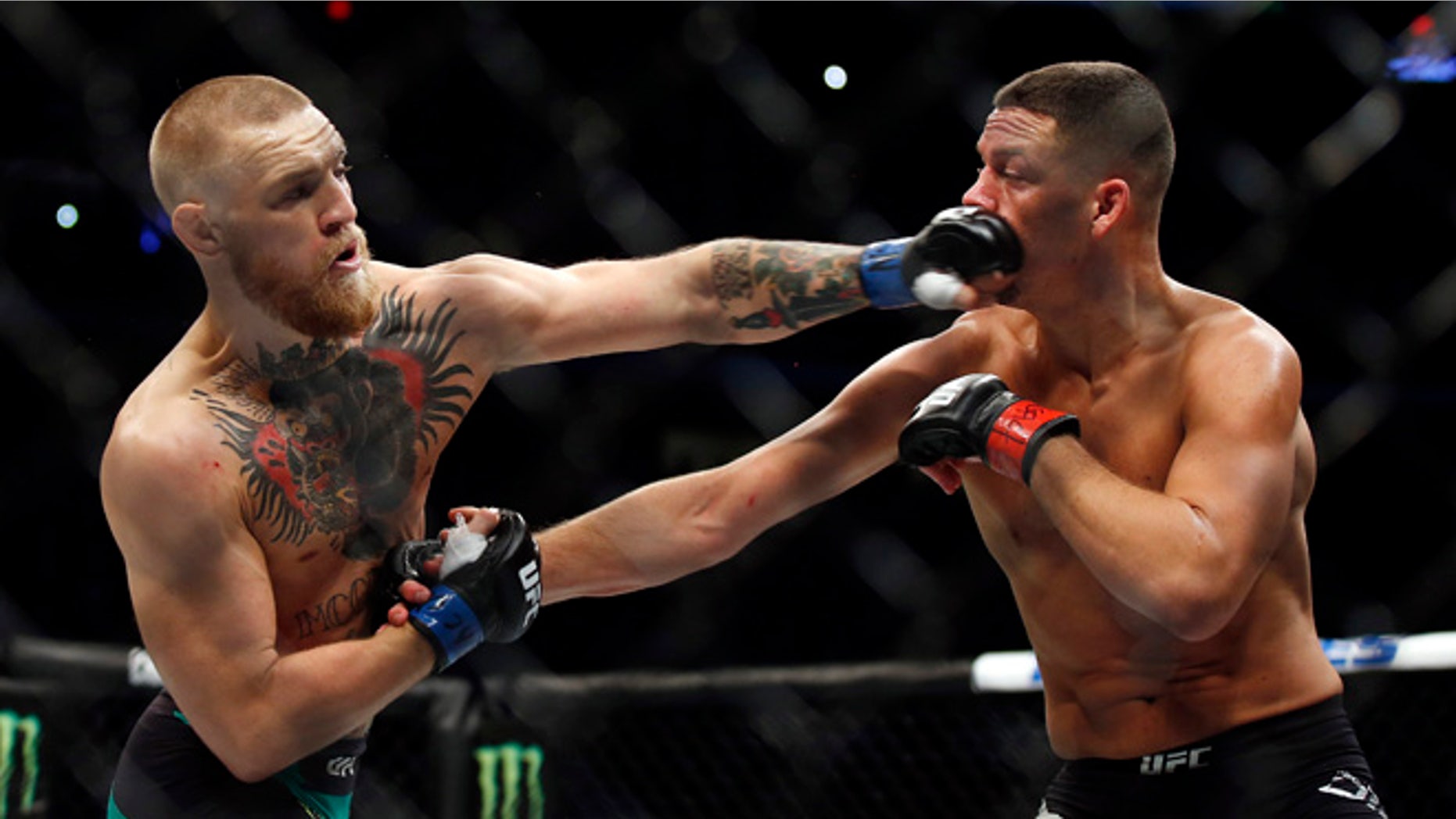 Conor McGregor, left, punches Nate Diaz during their welterweight mixed martial arts bout at UFC 202 on Saturday, Aug. 20, 2016, in Las Vegas. McGregor won by split decision. (AP Photo/Isaac Brekken)
