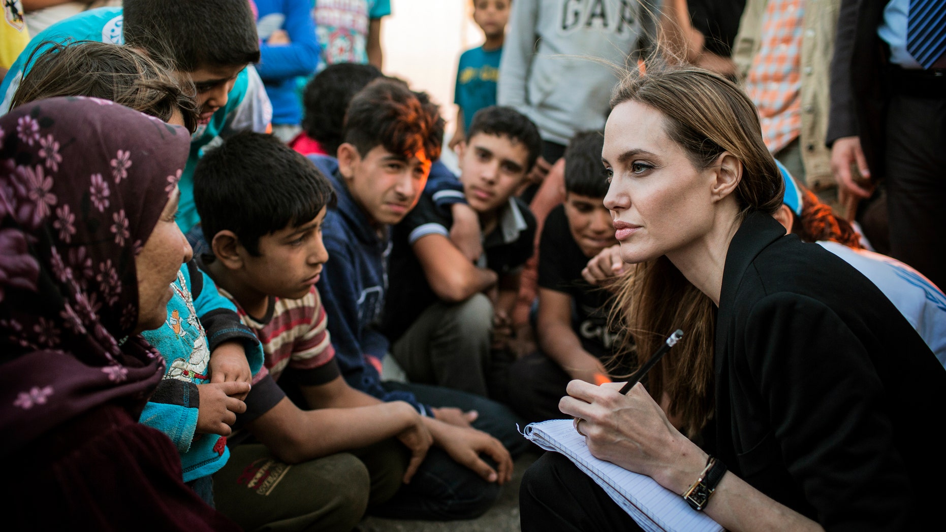 June 18, 2013 - Special envoy Angelina Jolie taking notes as she speaks with Syrian refugees in a Jordanian military camp near the Syria-Jordan border. (photo released by the United Nations High Commissioner for Refugees (UNHCR)