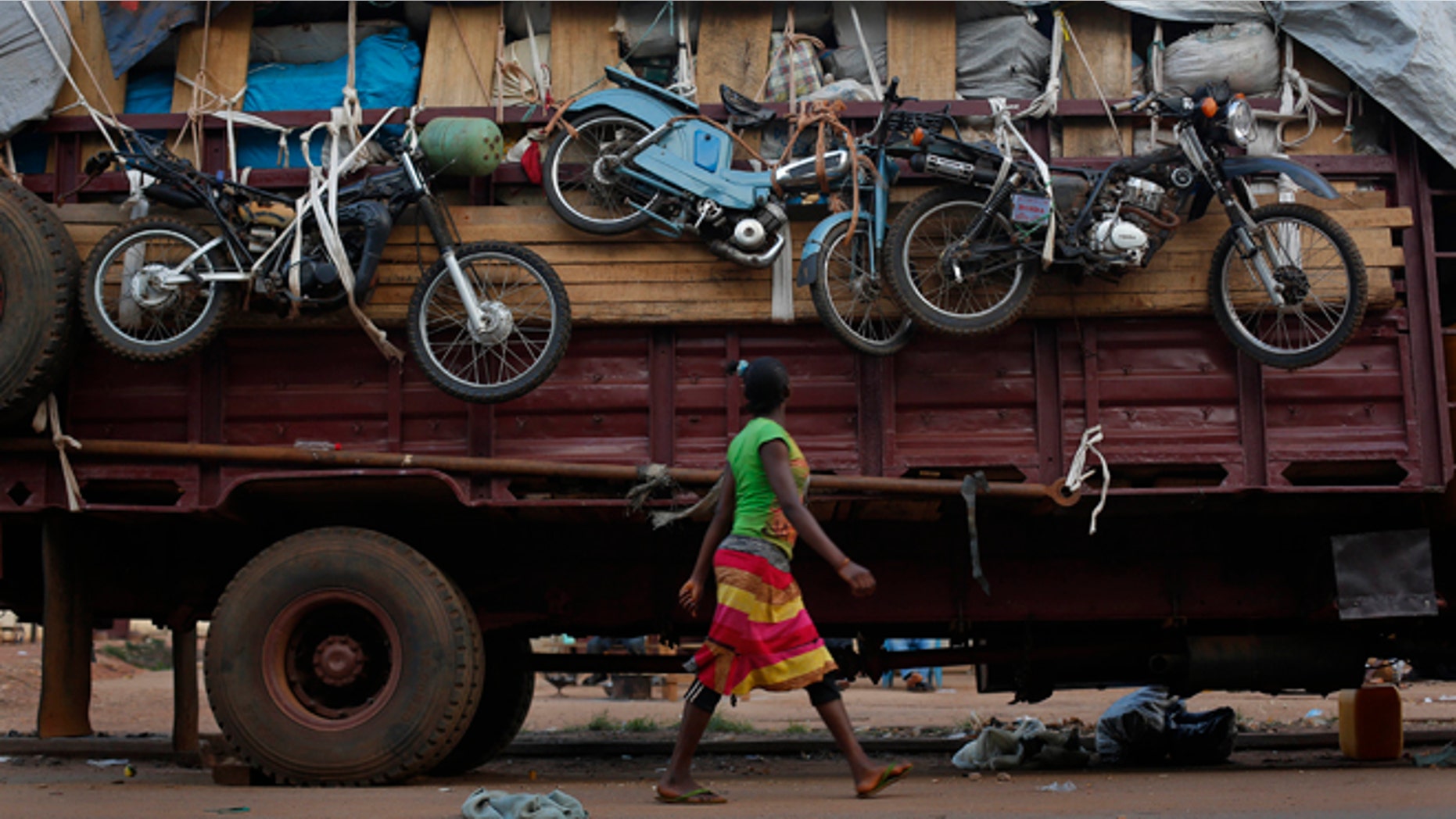 April 9, 2014: A woman walks past a truck waiting to leave for Chad loaded with goods belonging to Muslim residents of the PK5 district of Bangui, Central African Republic.