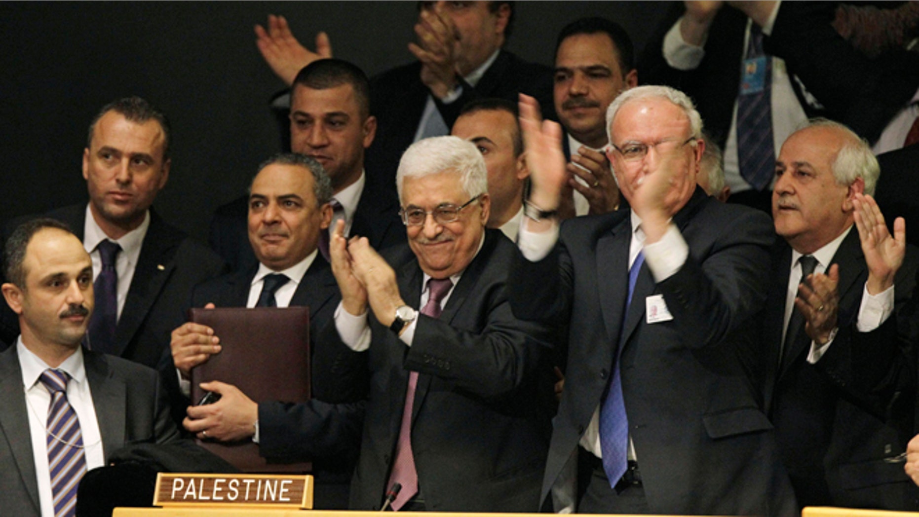 Nov. 29, 2012: Members of the Palestinian delegation react as they surround Palestinian President Mahmoud Abbas, center, applauding, during a meeting of the United Nations General Assembly after a vote on a resolution on the issue of upgrading the Palestinian Authority's status to non-member observer state passed in the United Nations in New York.