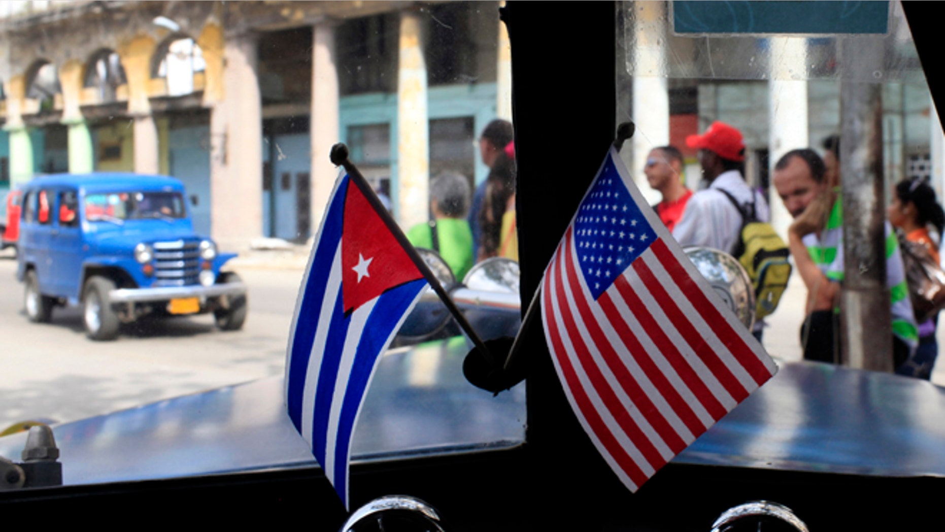 This March 22, 2013 file photo shows miniature flags representing Cuba and the U.S. displayed on the dash of an American classic car in Havana, Cuba.