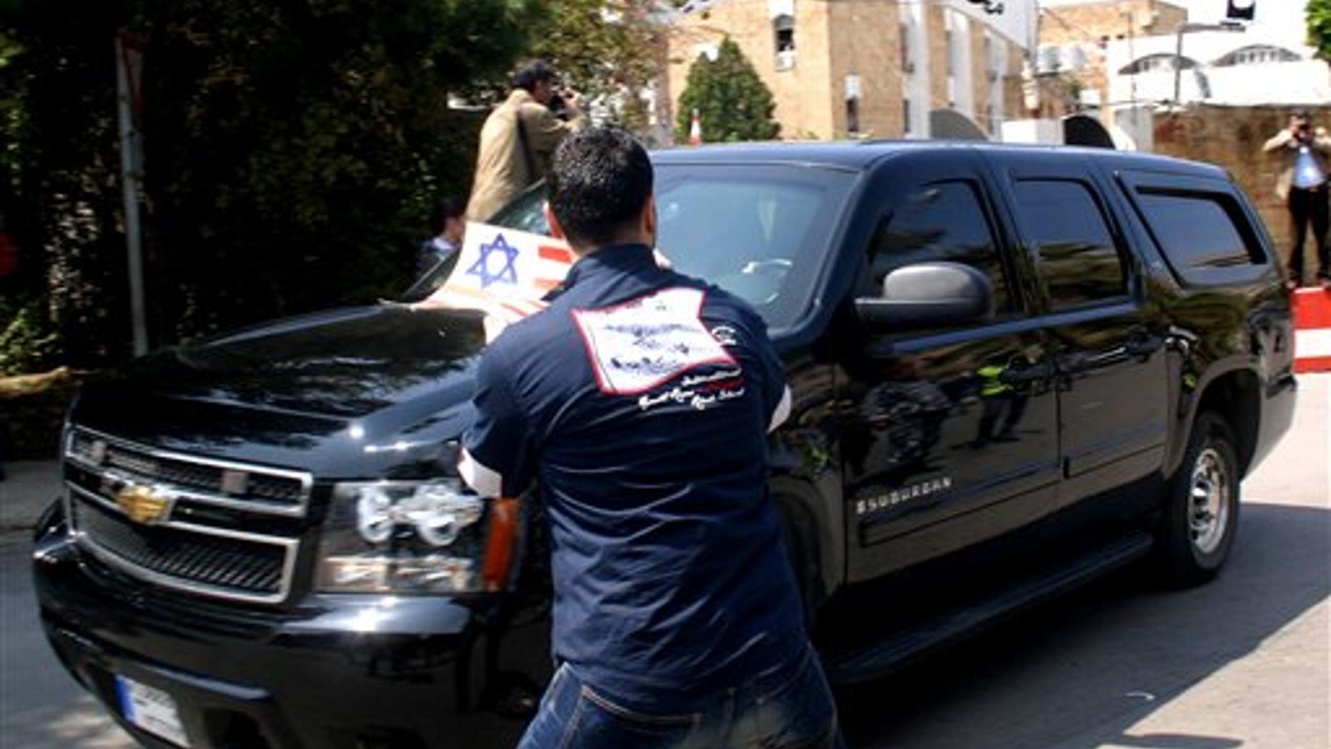 April 7: A Lebanese protester waves an anti-US placard in front the convoy of the U.S. embassy delegation as they leave a meeting with a Lebanese security forces commander, in the city of Sidon, Lebanon.