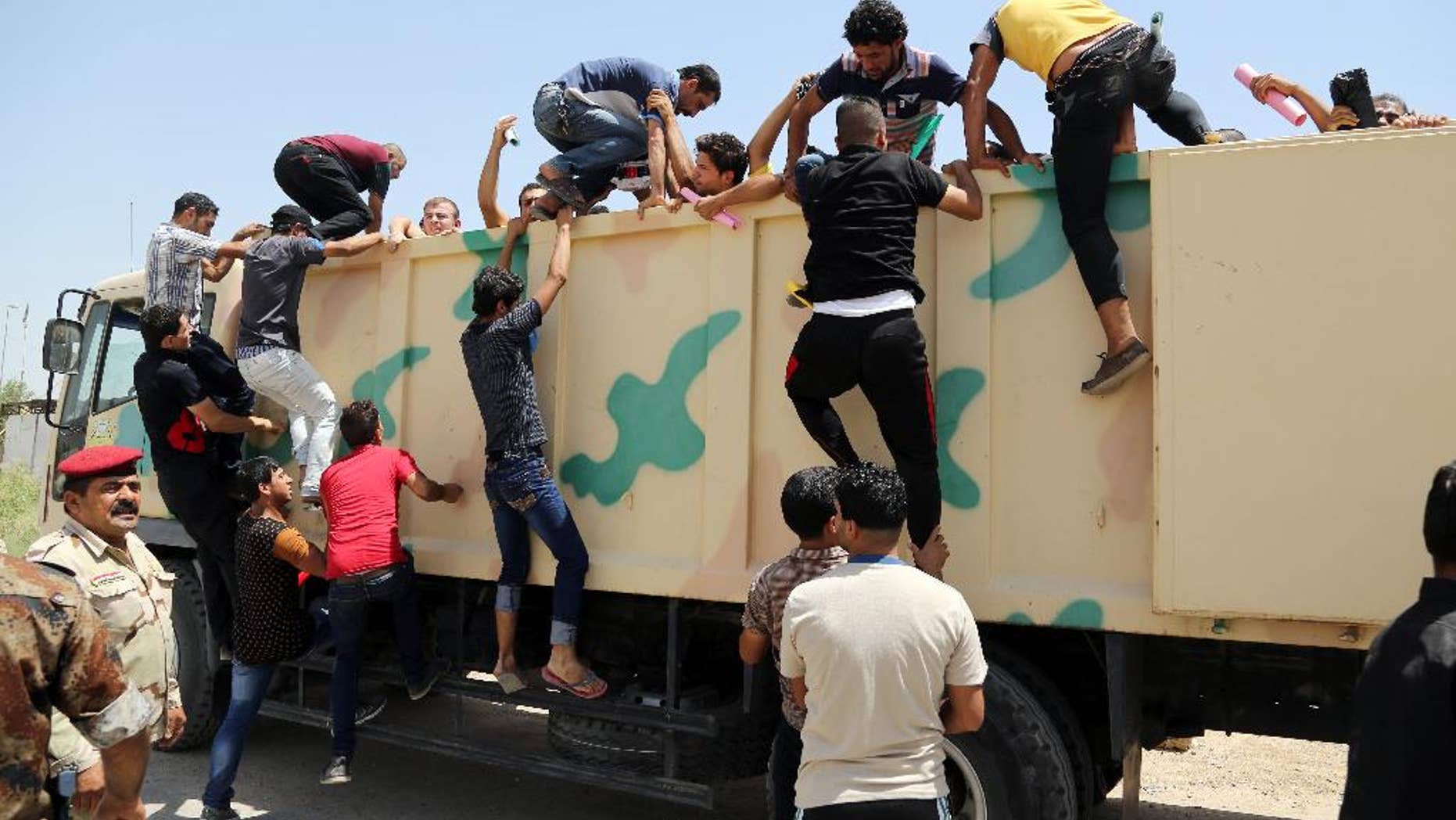 In this June 14, 2014, photo, Iraqi men board a military truck to join the Iraqi army at the main recruiting center in Baghdad, Iraq, after authorities urged Iraqis to help battle insurgents. U.S. spy agencies are scrambling to close intelligence gaps as they seek to support possible military action against the leaders of the al-Qaida-inspired militant group that has seized parts of Iraq. Intelligence officials are trying to provide options for President Barack Obama as he considers how to counter an insurgency he says poses a threat to Americans.(AP Photo/Karim Kadim, File)