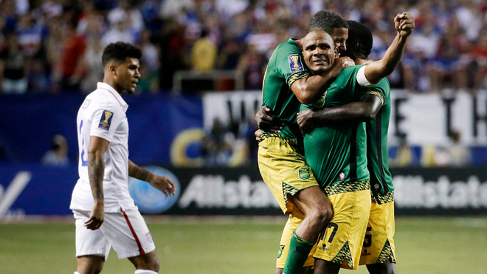Jamaicas Rudolph Austin, facing camera, celebrates with teammates Joel McAnuff, left, and Je-Vaughn Watson, right, as United States DeAndre Yedlin walks off the pitch after Jamaica defeated the United States 2-1 in a CONCACAF Gold Cup soccer semifinal Wednesday, July 22, 2015, in Atlanta. (AP Photo/David Goldman)