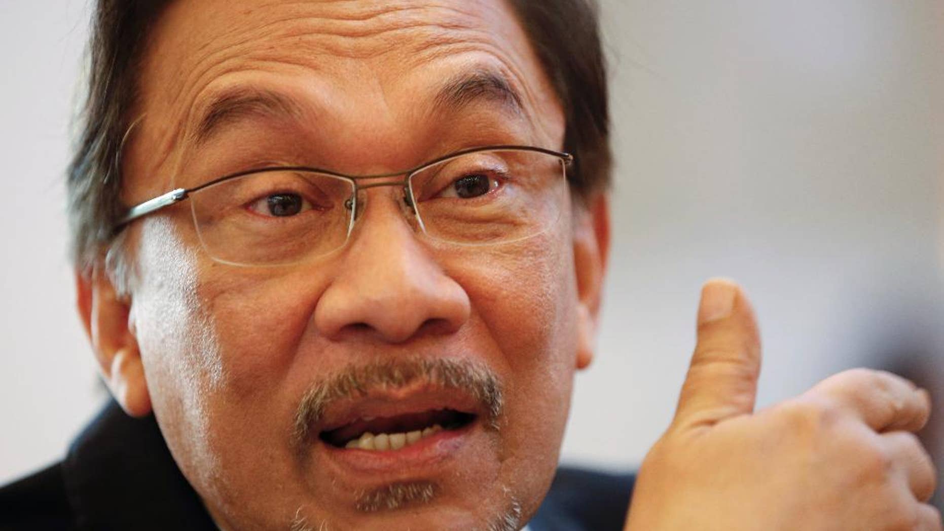 FILE - In this Oct. 31, 2014, file photo, Malaysian opposition leader Anwar Ibrahim speaks with his party members during a tea break of his final hearing in Putrajaya, Malaysia. The sodomy conviction of Malaysia's opposition leader has set back, but not unraveled, Washington's improved ties with a country that is becoming increasingly important for U.S. diplomacy and trade policy in Asia. (AP Photo/Vincent Thian, File)