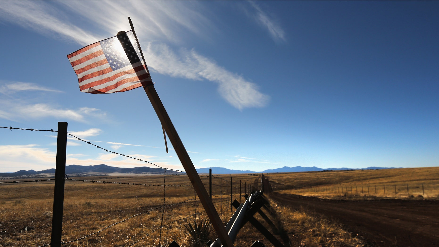 SONOITA, AZ - FEBRUARY 26: An American flag flies at the U.S.-Mexico border on February 26, 2013 near Sonoita, Arizona. The Federal government has increased the Border Patrol presence in Arizona, from some 1,300 agents in the year 2000 ro 4,400 in 2012. The apprehension of undocumented immigrants crossing into the U.S. from Mexico has declined during that time from 600,016 in 2000 to 123,000 in 2012. (Photo by John Moore/Getty Images)