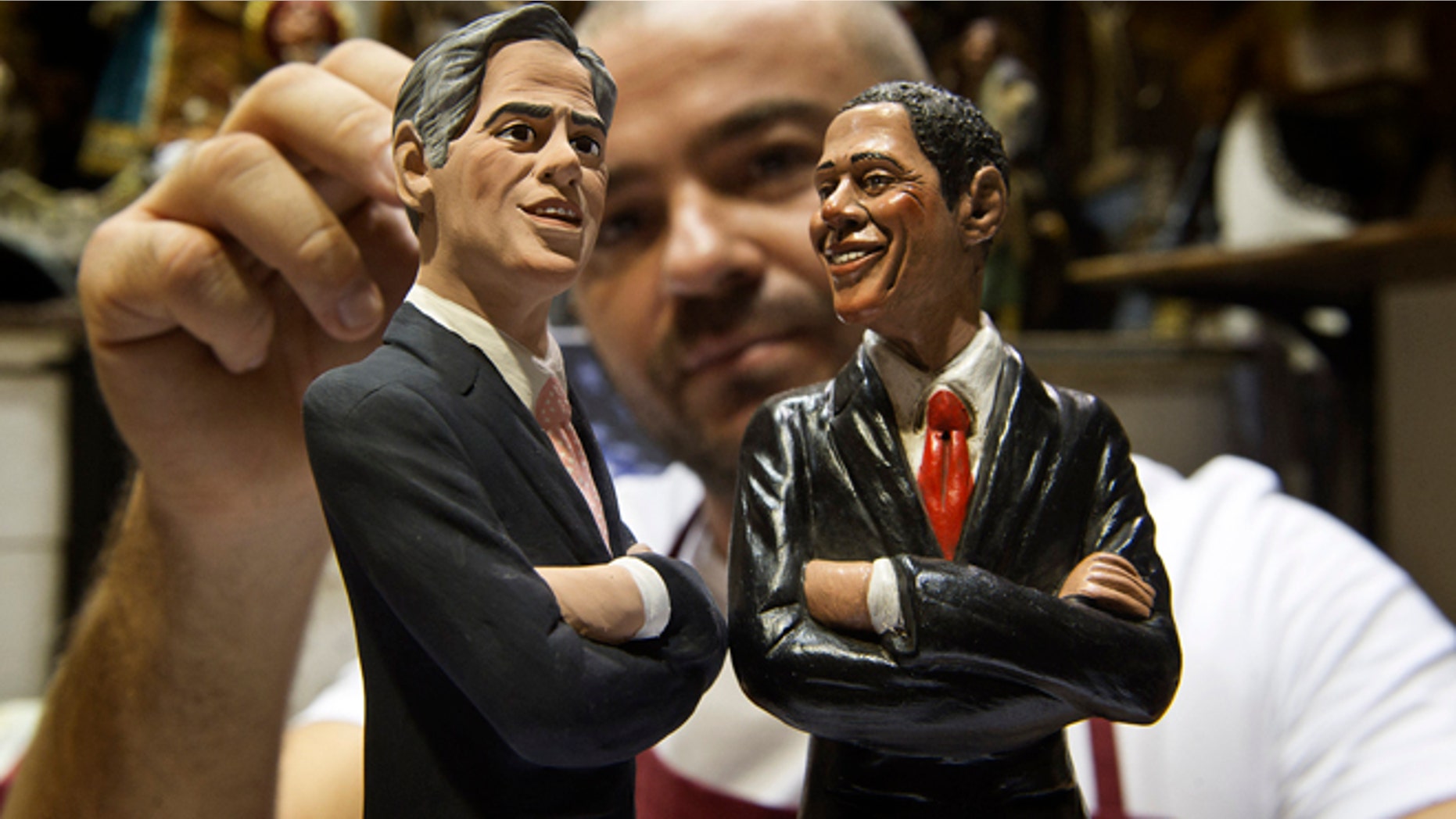 Italian Nativity scenes designer Genny Di Virgilio puts the final touches on two statuettes depicting President Barack Obama, right, and Republican rival Mitt Romney in his shop in Naples, Italy, Monday, Oct. 22, 2012, hours ahead of their third and final presidential debate in Boca Raton, Florida. (AP Photo/Salvatore Laporta)