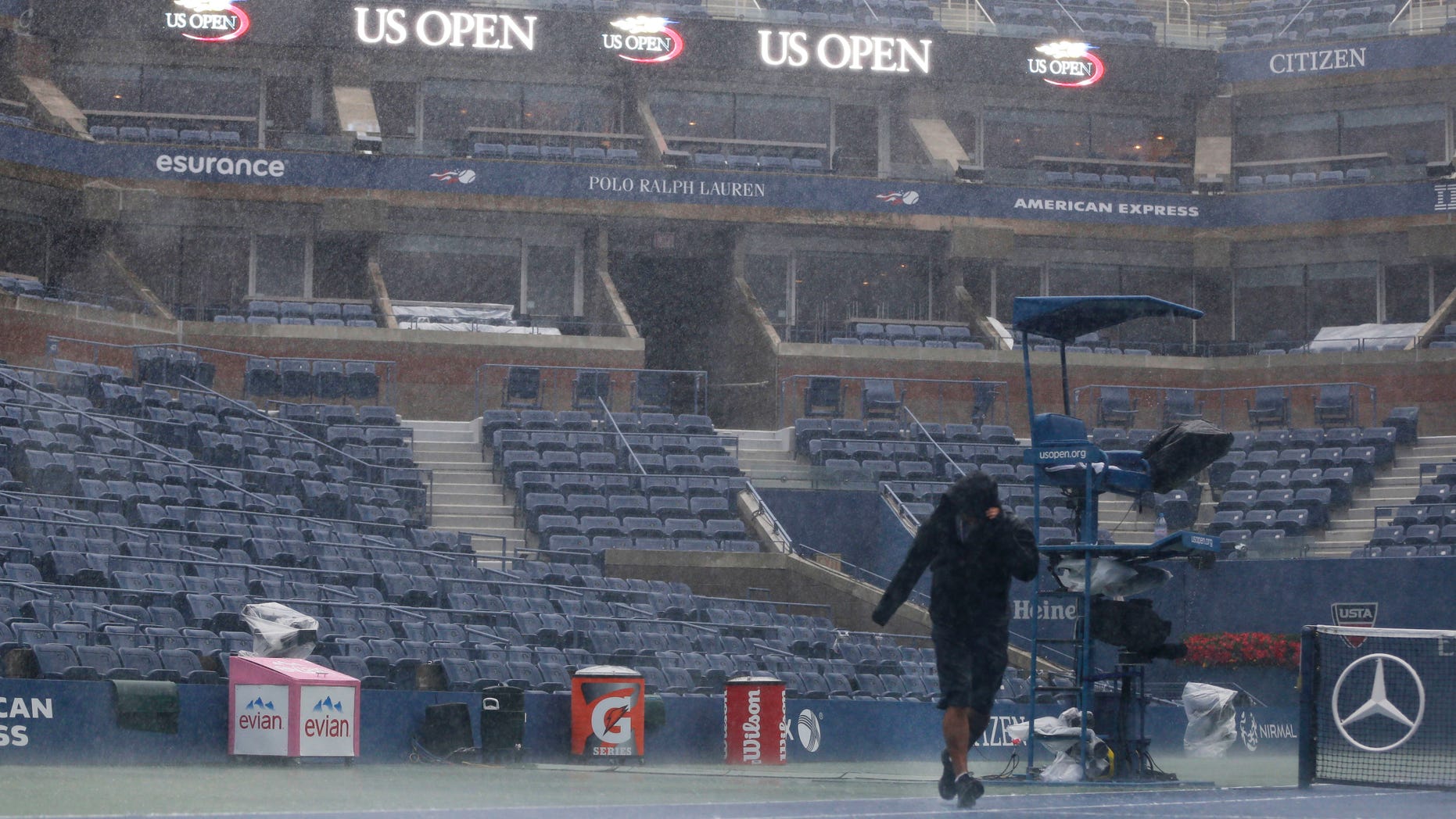 Sept. 8, 2012: A television crewman struggles during a rain delay at the 2012 US Open tennis tournament in New York.