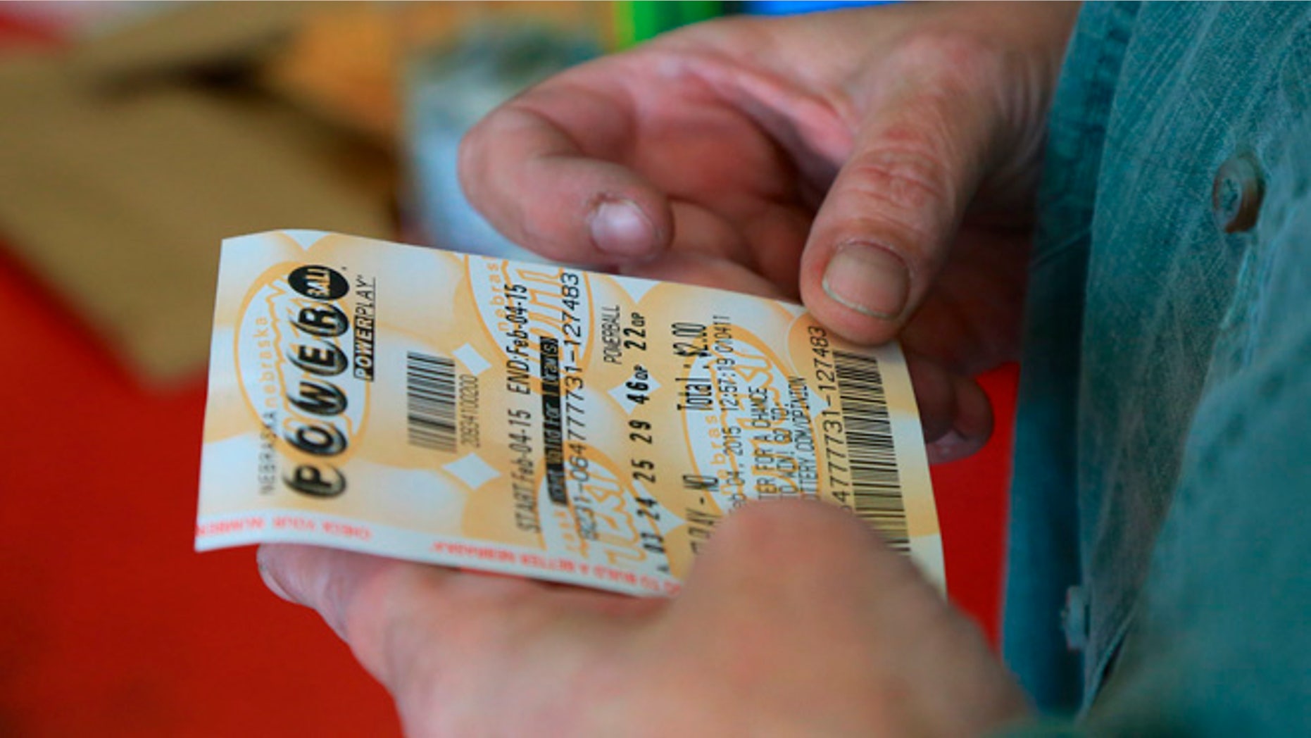 Feb. 4, 2015: A customer inspects the Powerball ticket she purchased at a U-Stop store in Lincoln, Neb.