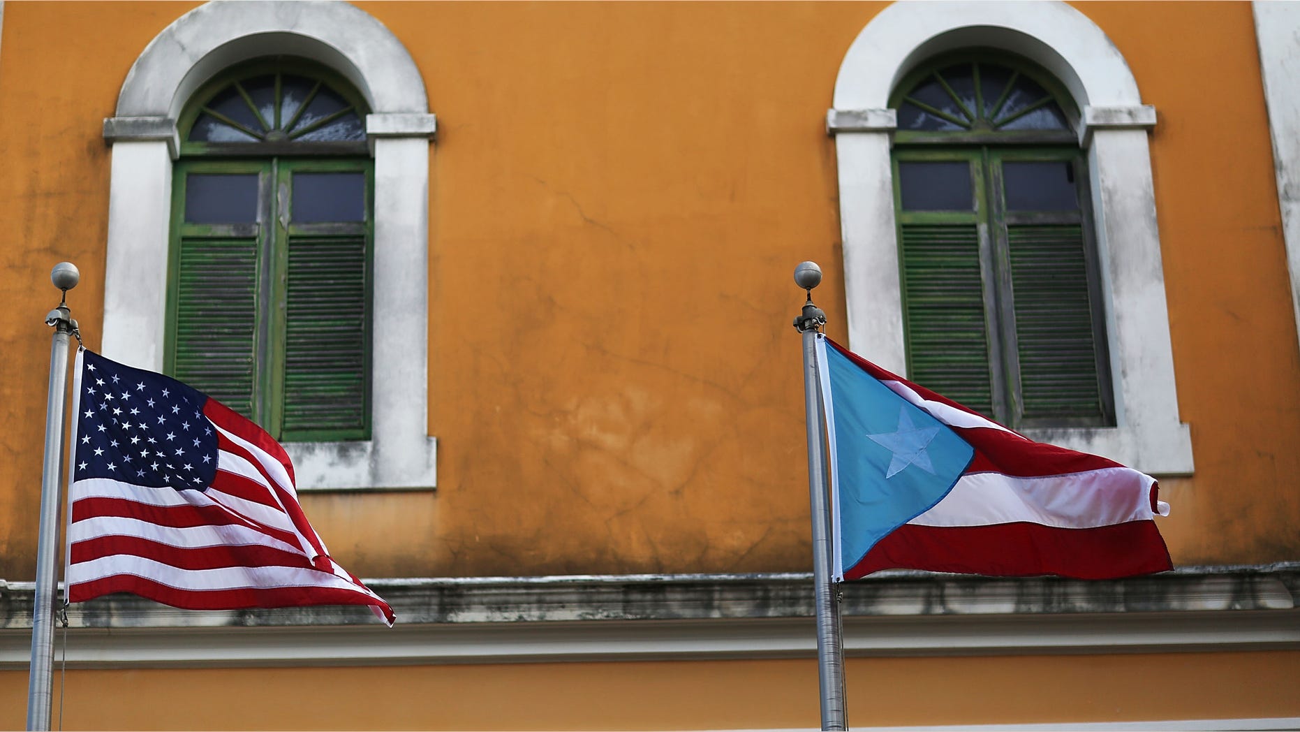 An American flag and Puerto Rican flag fly next to each other in Old San Juan.
