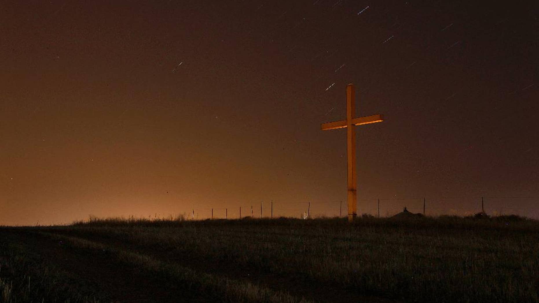 FILE-This photo taken May 3, 2013, shows a long time exposure showing the stars in the sky over a cross of "Panagia Chrisospiliotissa", a Christian Orthodox monastery outside of capital Nicosia, Cyprus. The number of Americans who don't affiliate with a particular religion has grown to 56 million in recent years, making the faith group researchers call "nones" the second-largest in total numbers behind evangelicals, according to a Pew Research Center study released Tuesday, May 12, 2015. (AP Photo/Petros Karadjias, File)