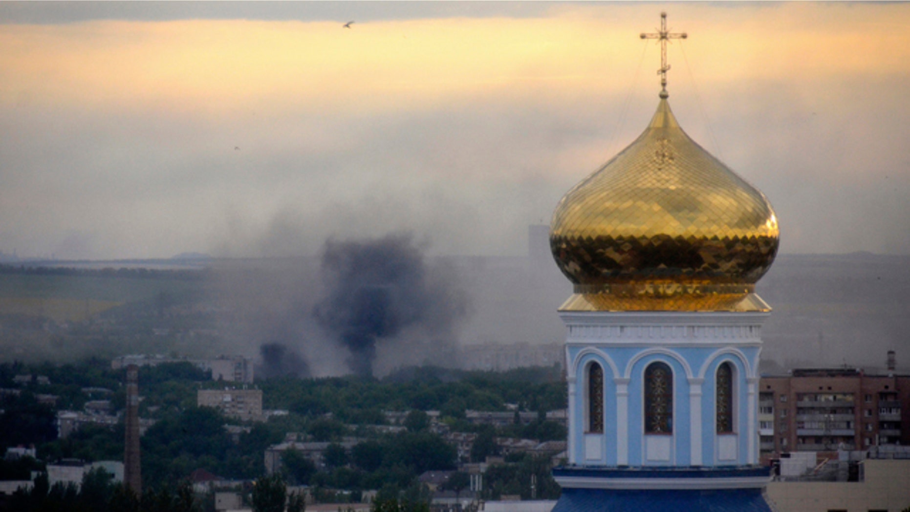 FILE - This July 14, 2014 file photo shows black smoke billowing following a mortar attack during fighting between Ukrainian government troops and pro-Russian fighters in Luhansk, Ukraine. (AP Photo, Yuri Snegirev, Rossiyiskaya Gazeta, File)
