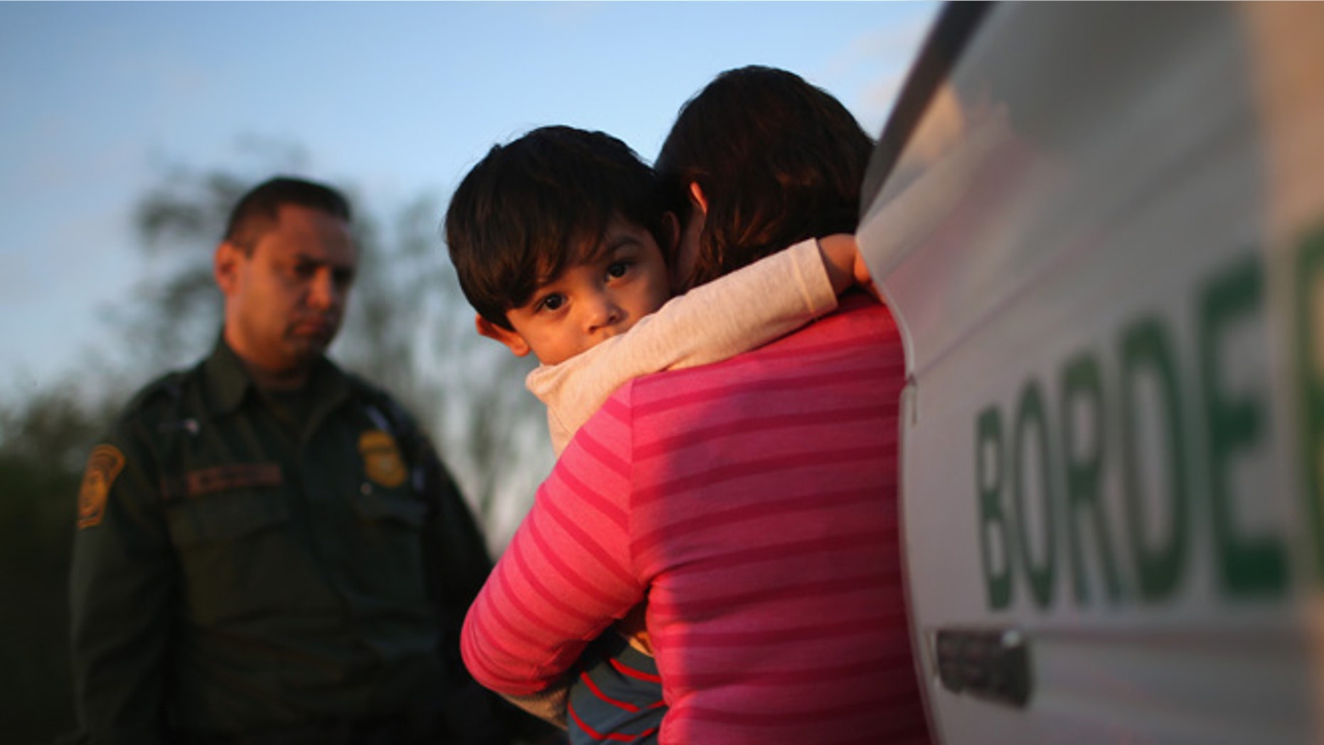 RIO GRANDE CITY, TX - DECEMBER 07: A one-year-old from El Salvador clings to his mother after she turned themselves in to Border Patrol agents on December 7, 2015 near Rio Grande City, Texas. They had just illegally crossed the U.S.-Mexico border into Texas. The mother said she brought her son on the 24-day journey from El Salvador to escape violence in the Central American country. The number of migrant families and unaccompanied minors has again surged in recent months, even as the total number of illegal crossings nationwide has gone down over the previous year. (Photo by John Moore/Getty Images)