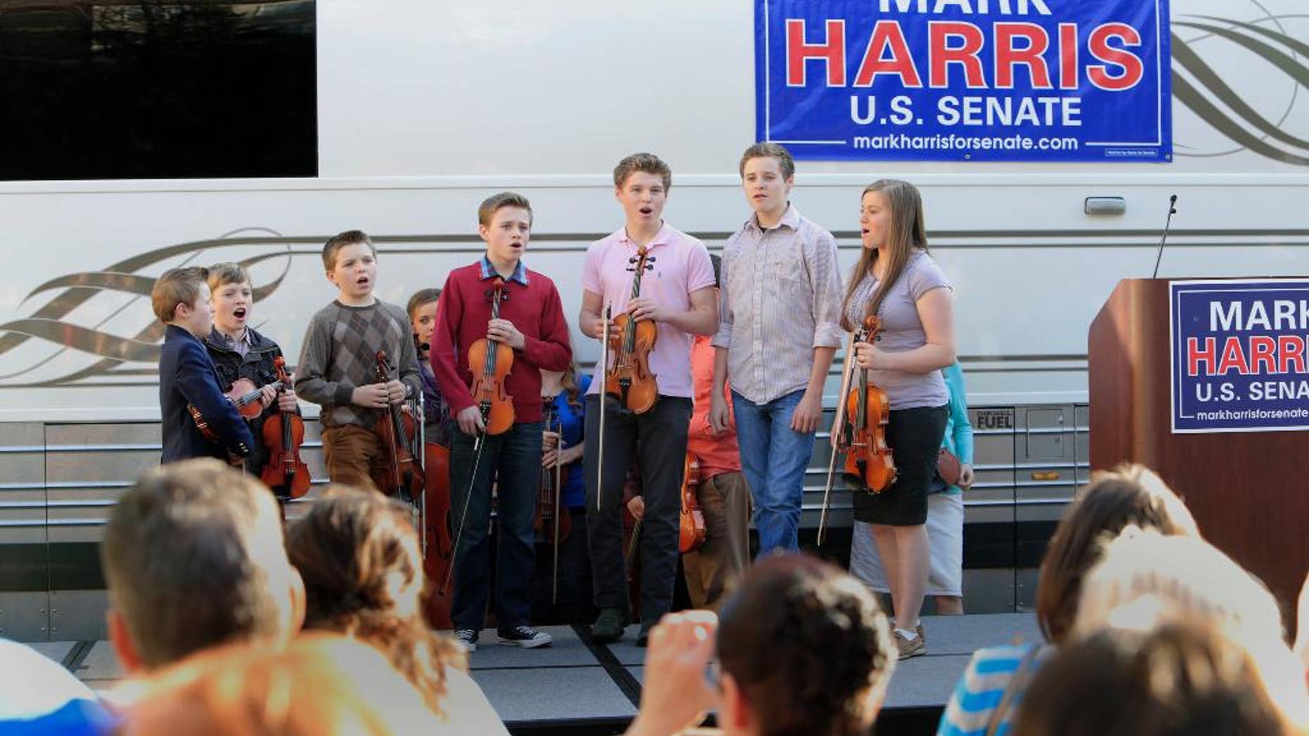FILE - In this March 14, 2014 file photo, children from the Duggar family sing during a campaign event for Rev. Mark Harris, who is seeking a Republican U.S. Senate nomination in the upcoming North Carolina primary, in Raleigh, N.C., The Duggars, with 19 children in all, star in a reality TV show. (AP Photo/Ted Richardson)