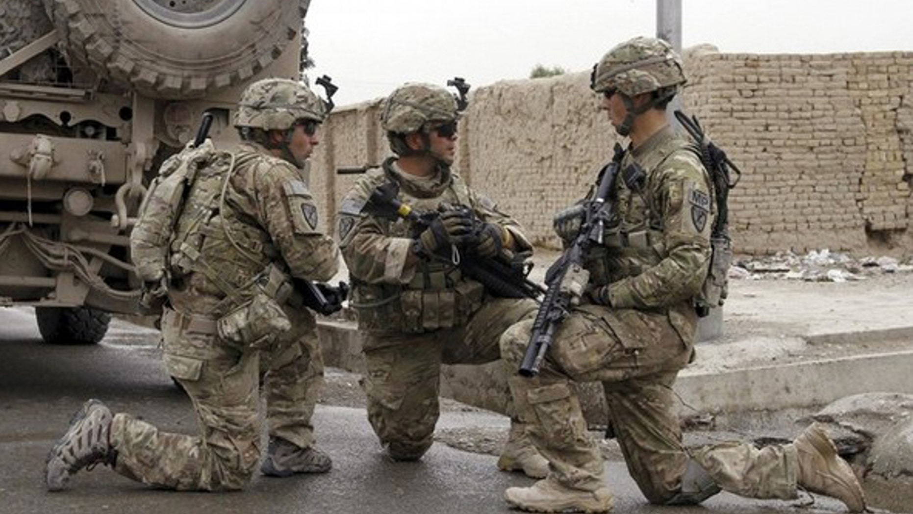 U.S. Army soldiers speak among themselves near a suicide bomb blast site in Kandahar April 14, 2011. A suicide bomber wounded three civilians, including two women, when he detonated his explosives before reaching the target of his attack in southern Kandahar province, said Khan Mohammad Mujahid, a senior Kandahar police official. REUTERS/Ahmad Nadeem (AFGHANISTAN - Tags: CIVIL UNREST MILITARY CRIME LAW)