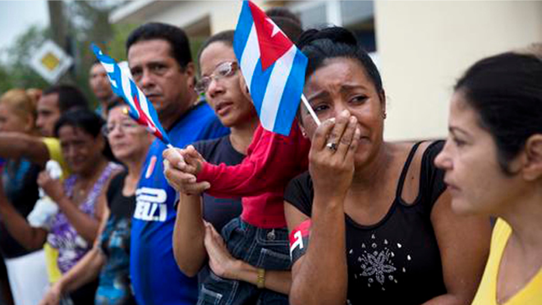 A woman weeps after watching the ashes of Cuban leader Fidel Castro along the main road in Baire, eastern Cuba, Saturday, Dec. 3, 2016. The convoy is on the last stage of a four-day journey across Cuba through small towns and cities where his rebel army fought its way to power nearly 60 years ago, to the eastern city of Santiago, where his remains will be interred on Sunday. (AP Photo/Rodrigo Abd)