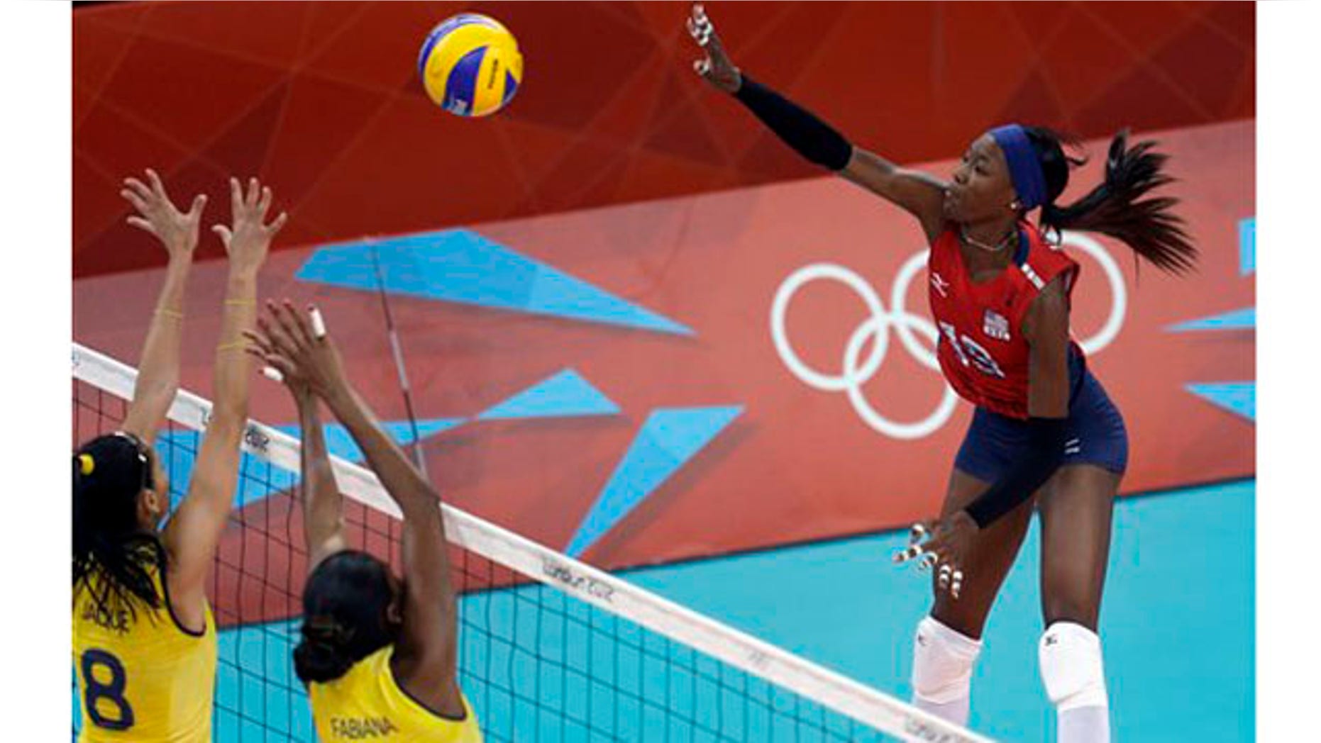 July 30, 2012: United States Destinee Hooker, right, spikes the ball over Brazil's Jaqueline Carvalho (8) and Fabiana Claudino (1) during a women's preliminary volleyball match at the 2012 Summer Olympics on Monday, in London.