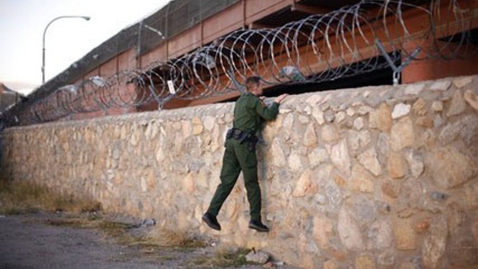 A United States Border Patrol agent checks an area under a bridge crossing between the United States and Mexico in El Paso, Texas November 14, 2010. El Paso lies across the border from Ciudad Juarez, Mexico, a violent city on the frontlines of Mexico's war against drug cartels. Picture taken November 14, 2010.