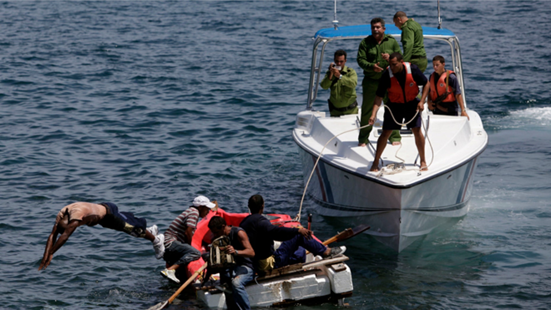 In this June 4, 2009 file photo, Cuban coast guards, right, stop seven men trying to migrate illegally to the U.S. on a foam raft near Havana's Malecon. No one was arrested, according to police.