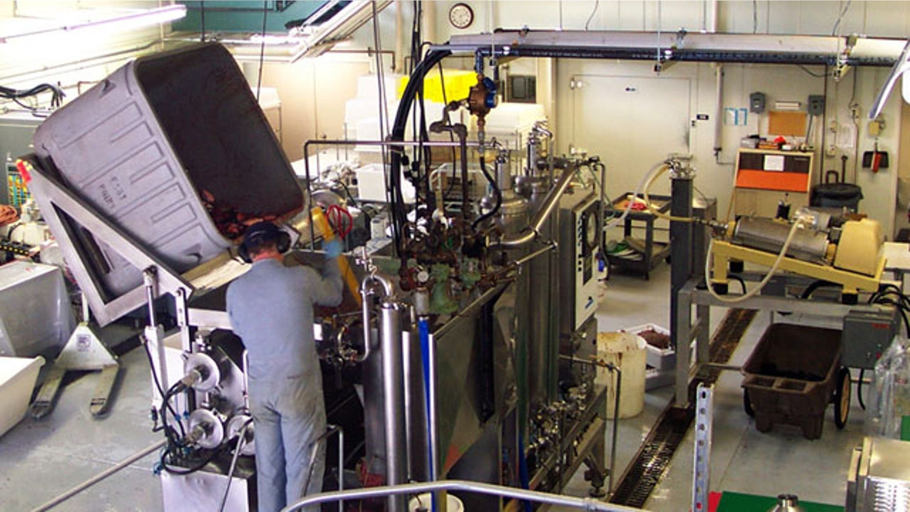 FILE: A technician dumps seafood byproducts into a hydrolysis machine at the Fishery Industrial Technology Center in Kodiak, Alaska.