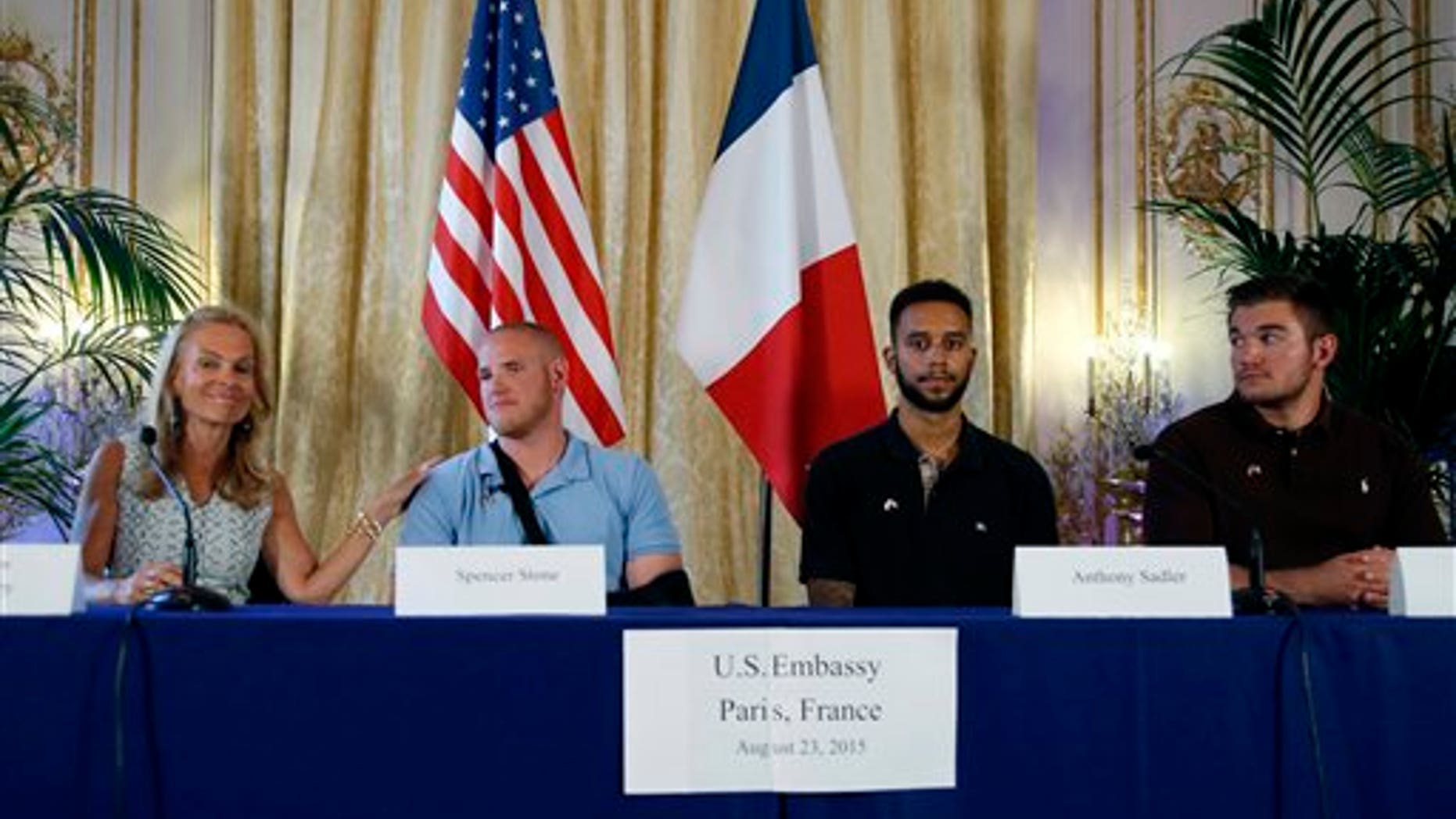 From left, U.S. Ambassador to France Jane D. Hartley, U.S. Airman Spencer Stone, Anthony Sadler, and National Guardsman Alek Skarlatos at press conference in Paris, France, Sunday, Aug. 23, 2015.. (AP Photo/Francois Mori)