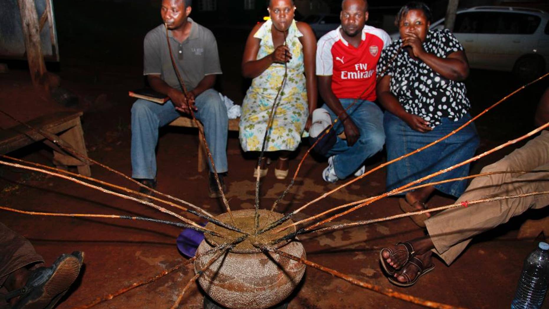 In this photo taken Sunday, Oct. 18, 2015, Ugandans drink a local brew known as "malwa" at the Charismatic Club in the Kitintale district of Kampala, Uganda. With beer sales slowing in North America and Europe, Anheuser-Busch InBev has agreed to pay more than $100 billion for rival SABMiller, in large part to tap burgeoning growth in Africa, where many people still buy their beer from small neighborhood brewers. (AP Photo/Stephen Wandera)