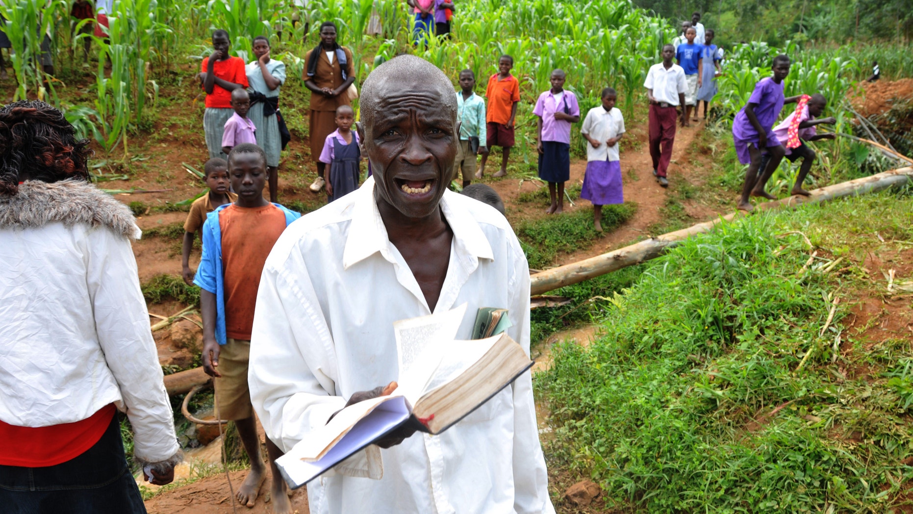 June 26, 2012: A man holding a bible cries out for God's mercy at the landslide in Bududa, about 250km east of Uganda capital Kampala.