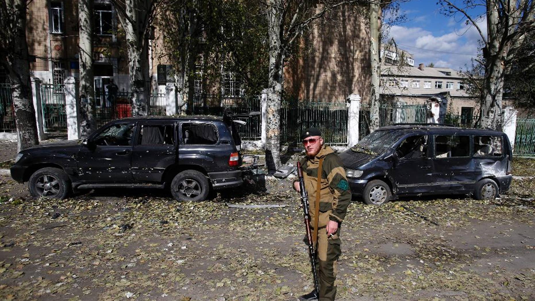 Oct. 1, 2014: A pro-Russian rebel guards a damaged school after shelling in the town of Donetsk, eastern Ukraine. Rebels in eastern Ukraine appear to be successfully closing in on the government-held airport of Donetsk, a strategic victory for the pro-Russian separatists that further undermines a shaky cease-fire in the region.