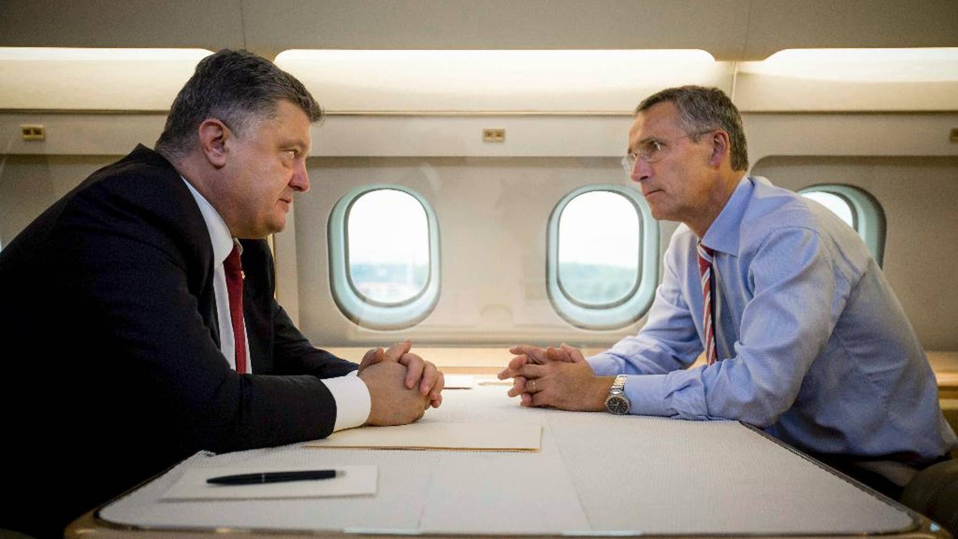 Ukrainian President Petro Poroshenko, left, and NATO Secretary General Jens Stoltenberg talk in a helicopter on the way to a military training ground outside Lviv, western Ukraine, Monday, Sept. 21, 2015. Stoltenberg arrived in Ukraine for NATO-Ukraine joint exercises. (Mikhail Palinchak, Pool Photo via AP )
