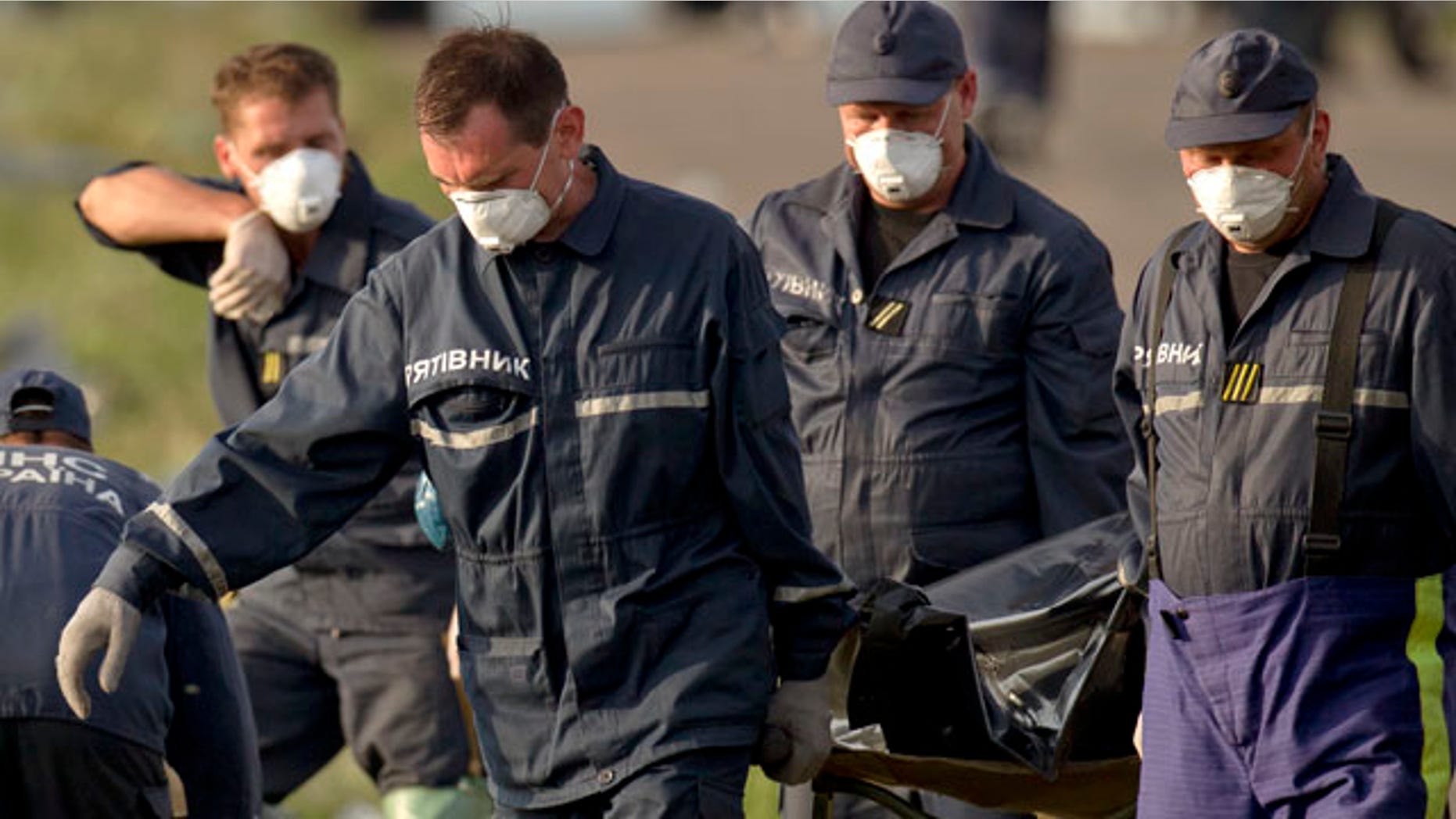 July 19, 2014: Emergency workers carry the body of a victim at the crash site of Malaysia Airlines Flight 17 near the village of Hrabove, eastern Ukraine. (AP Photo/Vadim Ghirda)