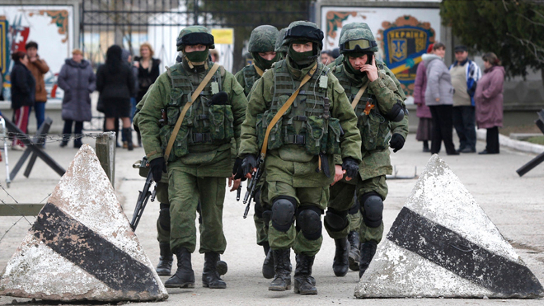 Pro Russian soldiers guard Ukraine's infantry base in Perevalne, Ukraine, Tuesday, March 4, 2014. Russian President Vladimir Putin said Moscow reserves the right to use all means to protect Russians in Ukraine as U.S. Secretary of State John Kerry was on his way to Kiev. Tensions remained high in the strategic Ukrainian peninsula of Crimea with troops loyal to Moscow firing warning shots to ward off protesting Ukrainian soldiers. (AP Photo/Sergei Grits)