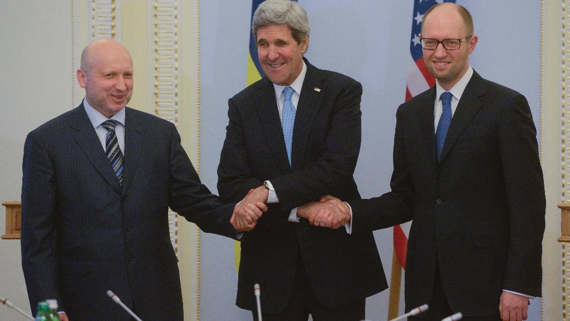 U.S. Secretary of State John Kerry, center, greets Ukrainian Prime Minister Arseniy Yatsenyuk, right, and parliament speaker Oleksandr Turchynov prior their meting in Kiev, Ukraine, Tuesday, March, 4, 2014. In a somber show of U.S. support for Ukraine’s new leadership, Secretary of State John Kerry walked the streets Tuesday where nearly 100 anti-government protesters were gunned down by police last month, and promised beseeching crowds that American aid is on the way. The Obama administration announced a $1 billion energy subsidy package in Washington as Kerry was arriving in Kiev.( (AP Photo/Andrew Kravchenko, pool)