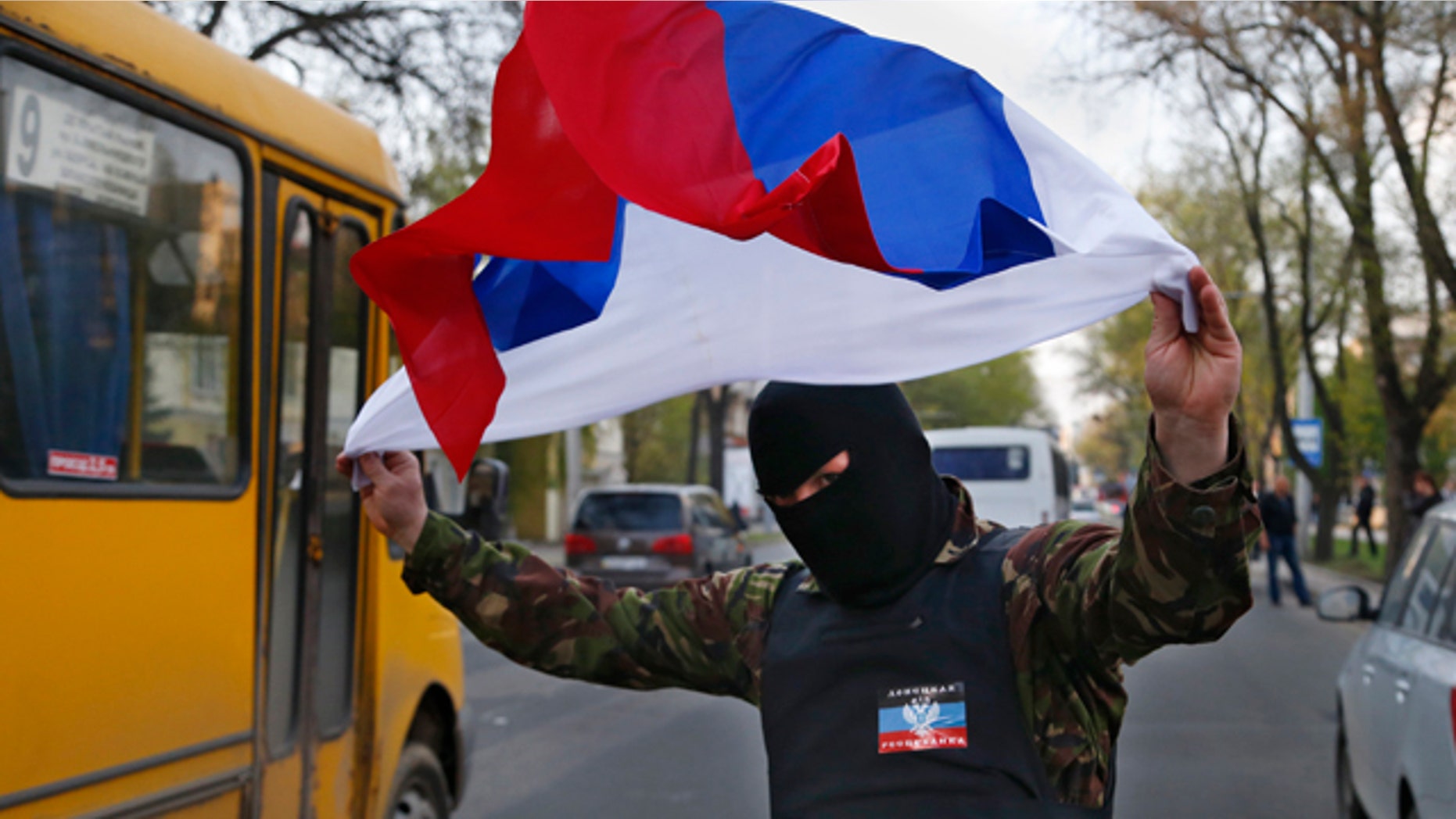 April 22, 2014: A masked pro Russia protestor waves the Russian flag in Donetsk, eastern Ukraine. (AP Photo/Sergei Grits)