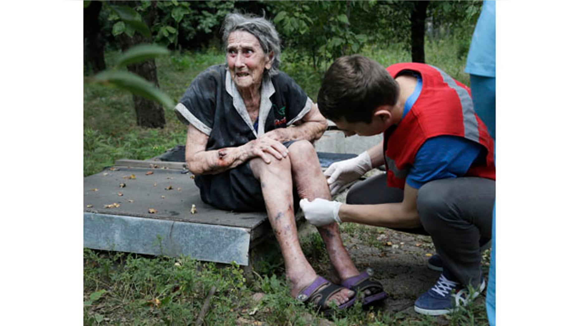 August 10, 2014: A wounded Ukrainian woman receives treatment after shelling in Donetsk. One person was killed and 10 injured in shelling that started early Sunday morning and continued into the day, city council spokesman Maxim Rovinsky told The Associated Press. (AP Photo/Sergei Grits)