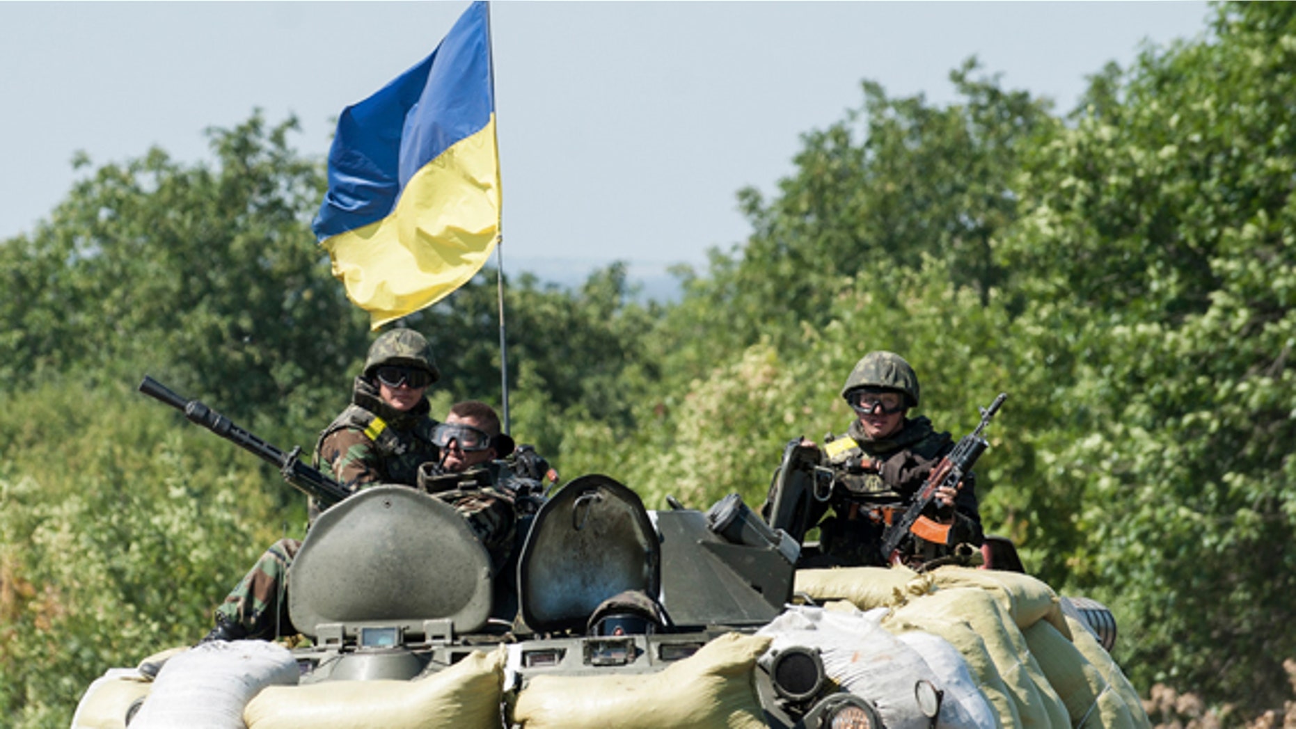 August 9, 2014: Ukrainian government troops sit atop of their military vehicle in Donetsk region. (AP Photo/Evgeniy Maloletka)