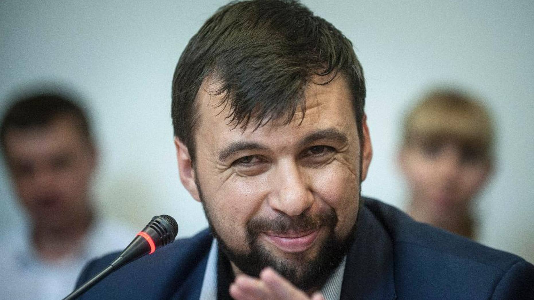 FILE - In this Wednesday May 14, 2014 file photo Denis Pushilin, leader of the insurgency that has declared an independent "people's republik" in the Donetsk region, speaks at a news conference in eastern Ukraine city of Donetsk. The Donetsk People’s Republic is starting to smell. Rotting garbage is piling up in the hallways of the government office building seized by separatists in eastern Ukraine. Telephones ripped from the walls are piled atop broken furniture and mounds of old files. The stench of sweat and stale cigarettes is everywhere. The guards, slouching men with pistols shoved in their pockets or flapping loosely in holsters, look increasingly bored. (AP Photo/Evgeniy Maloletka, File)