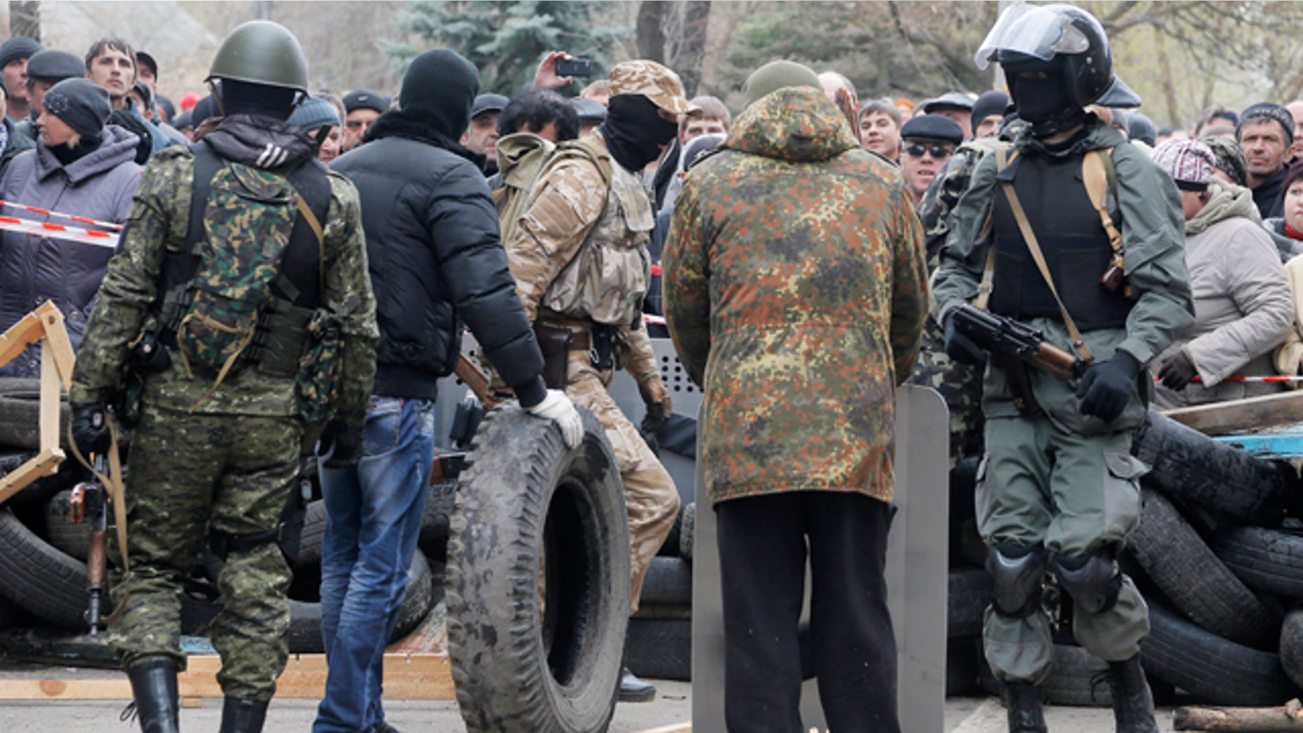 April 12, 2014: Armed pro-Russian activists occupy the police station and build a barricade as people watch on, in the eastern Ukrainian town of Slovyansk. Pro-Moscow protesters have seized a number of government buildings in the east over the past week, undermining the authority of the interim government in the capital, Kiev. (AP Photo/Efrem Lukatsky)
