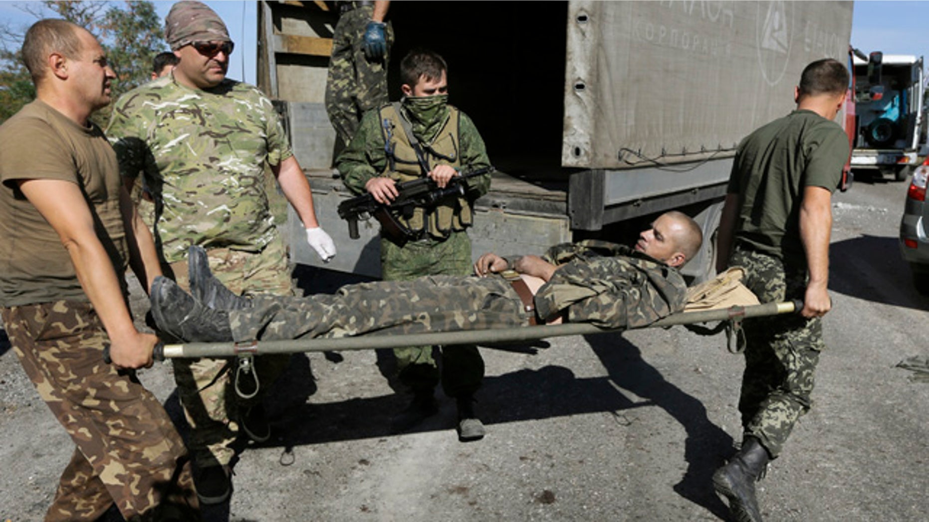 August 30, 2014: Ukrainian army personnel carry an Ukrainian government soldier injured by tank fire to an ambulance in the rebel-held town of Starobesheve. Half an hour later the soldier died. (AP Photo/Sergei Grits)