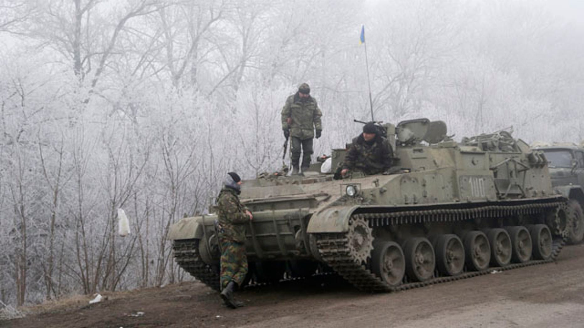 Feb. 15, 2015: Ukrainian government soldiers rest by armored vehicle on the road between the towns of Dabeltseve and Artemivsk. (AP Photo/Petr David Josek)