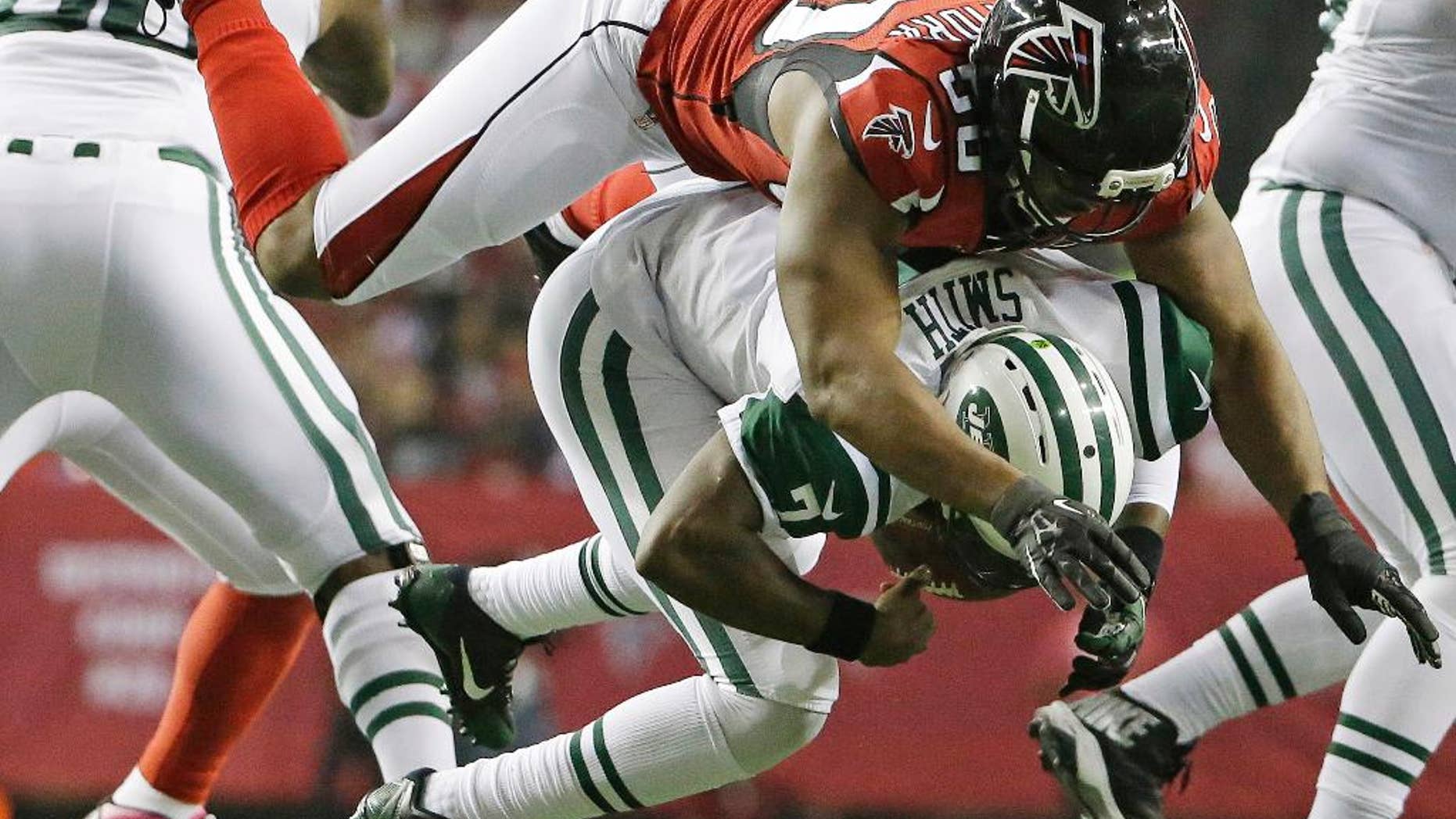 FILE - In this Oct. 7, 2013, file photo, New York Jets quarterback Geno Smith (7) is sacked by Atlanta Falcons defensive end Osi Umenyiora (50) during the second half of an NFL football game in Atlanta. Umenyiora still plays video games online with former Giants teammate Victor Cruz. On Sunday, Oct. 5, 2014, they'll go against each other for real for the first time. (AP Photo/David Goldman, File)